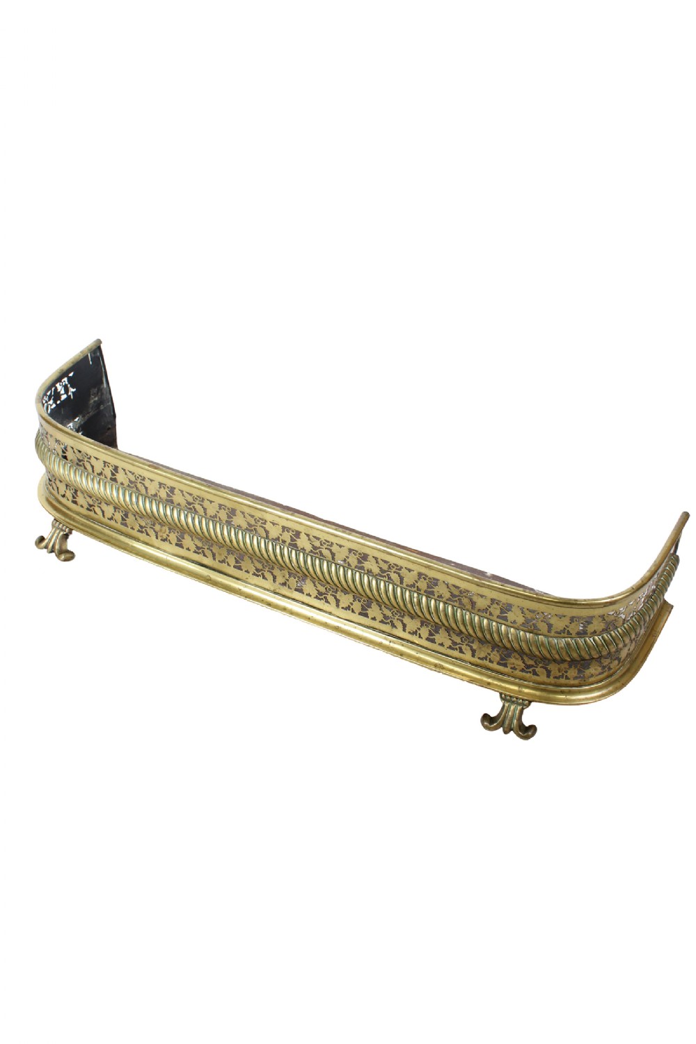 A low Victorian brass fire fender featuring pierced fretwork detail, gadrooned trim, and small scrolled metal feet.