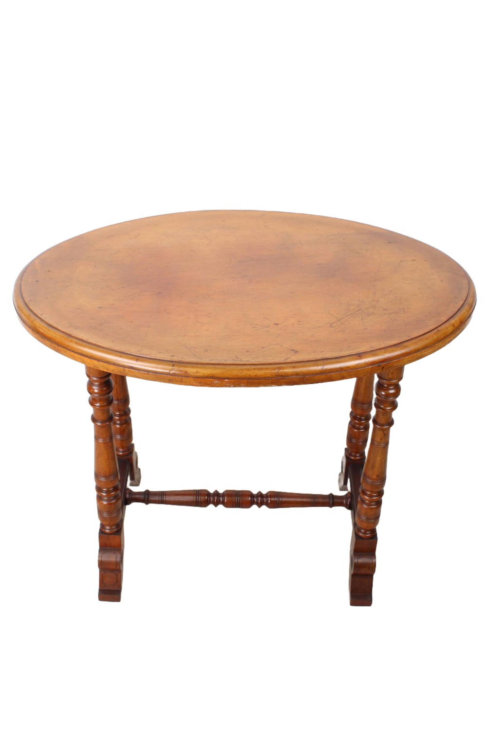 A small Victorian mahogany side table featuring an oval top, four turned support legs, a turned central stretcher, and shaped feet.