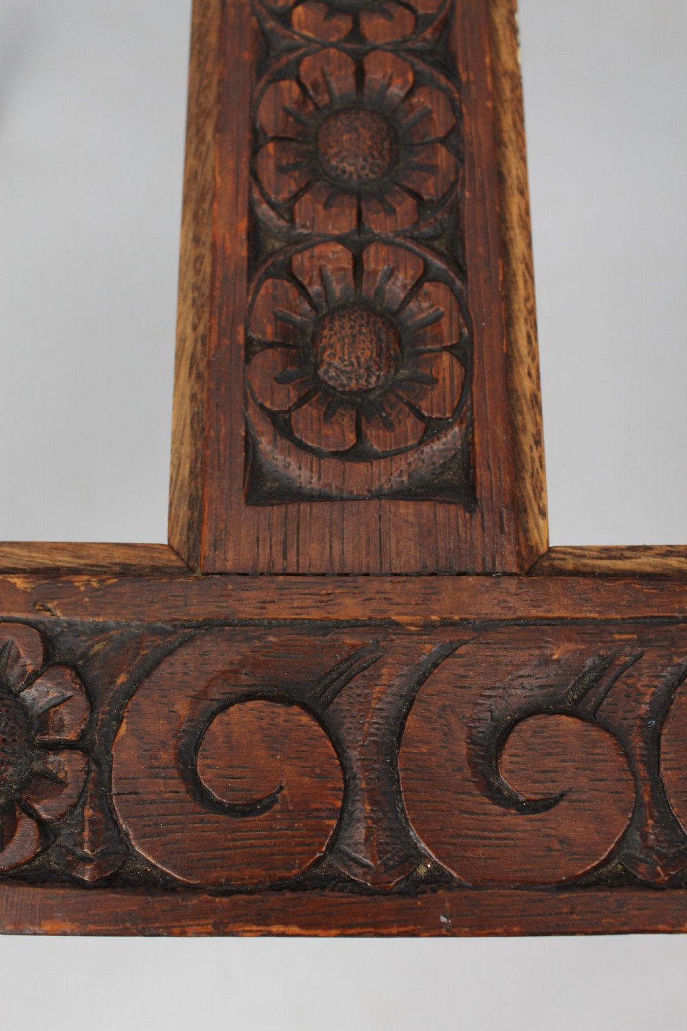 An Edwardian carved oak luggage stand with relief floral carving along the open top frame and turned wooden legs. View VII