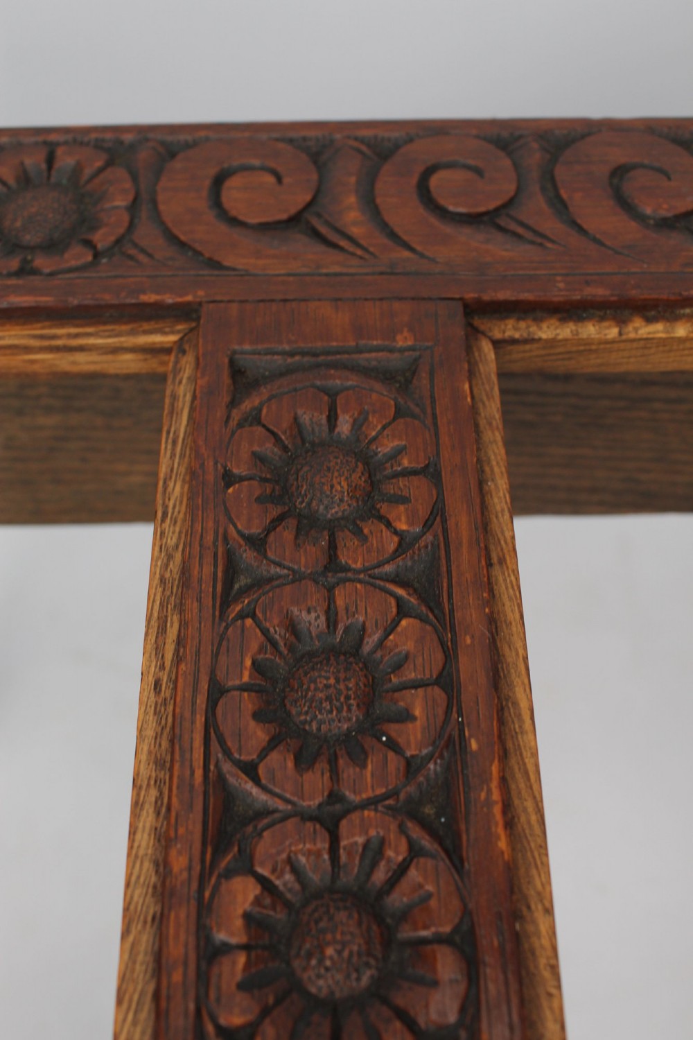 An Edwardian carved oak luggage stand with relief floral carving along the open top frame and turned wooden legs. View VIII