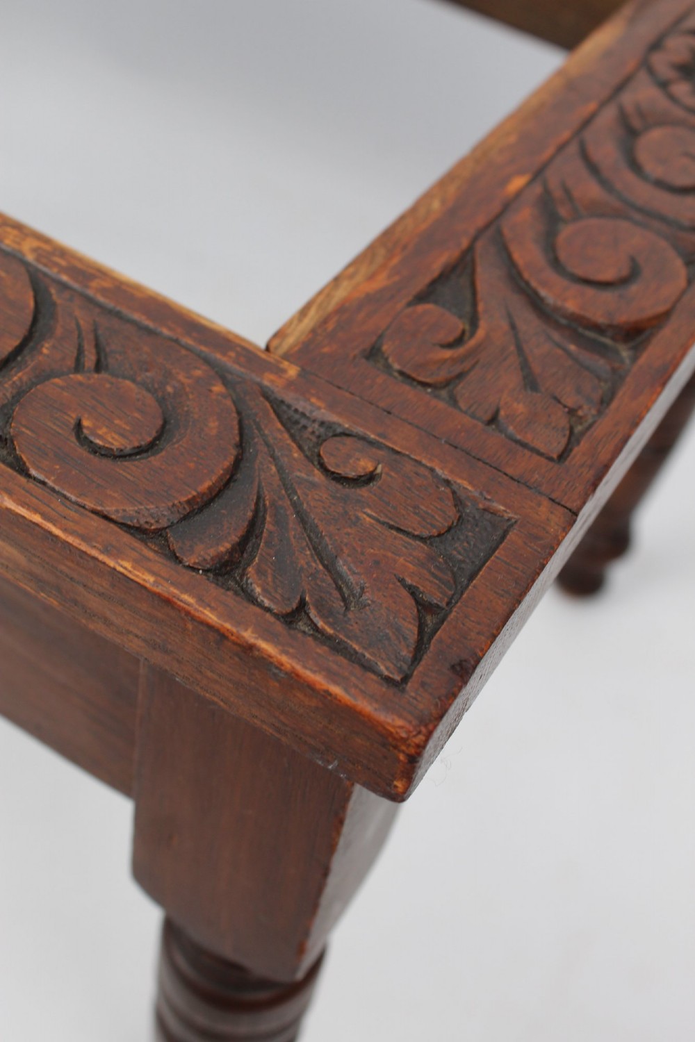 An Edwardian carved oak luggage stand with relief floral carving along the open top frame and turned wooden legs. View XIII