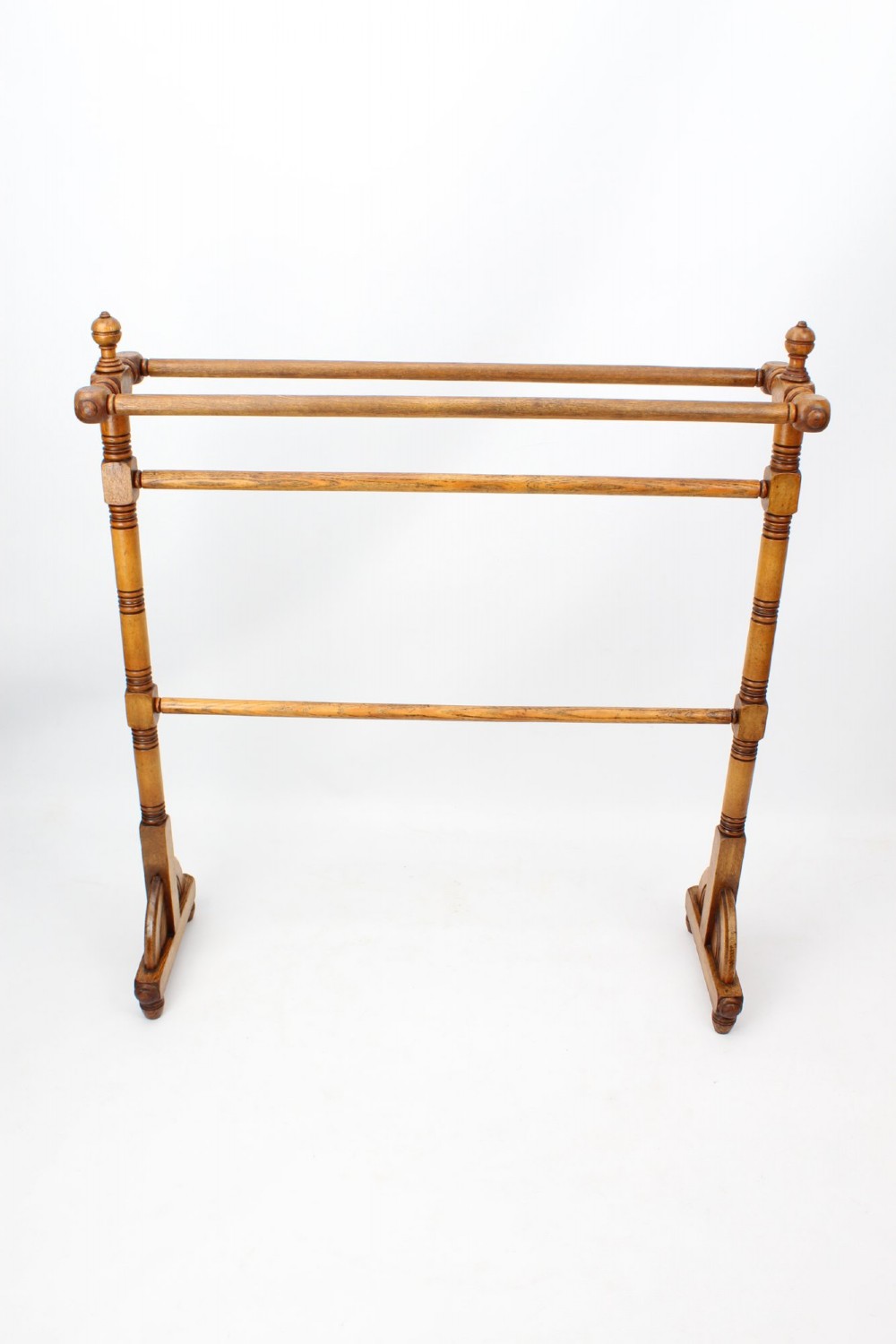 A Victorian ash freestanding towel rail featuring four horizontal bars, turned side columns with finials, and carved pedestal feet. View II