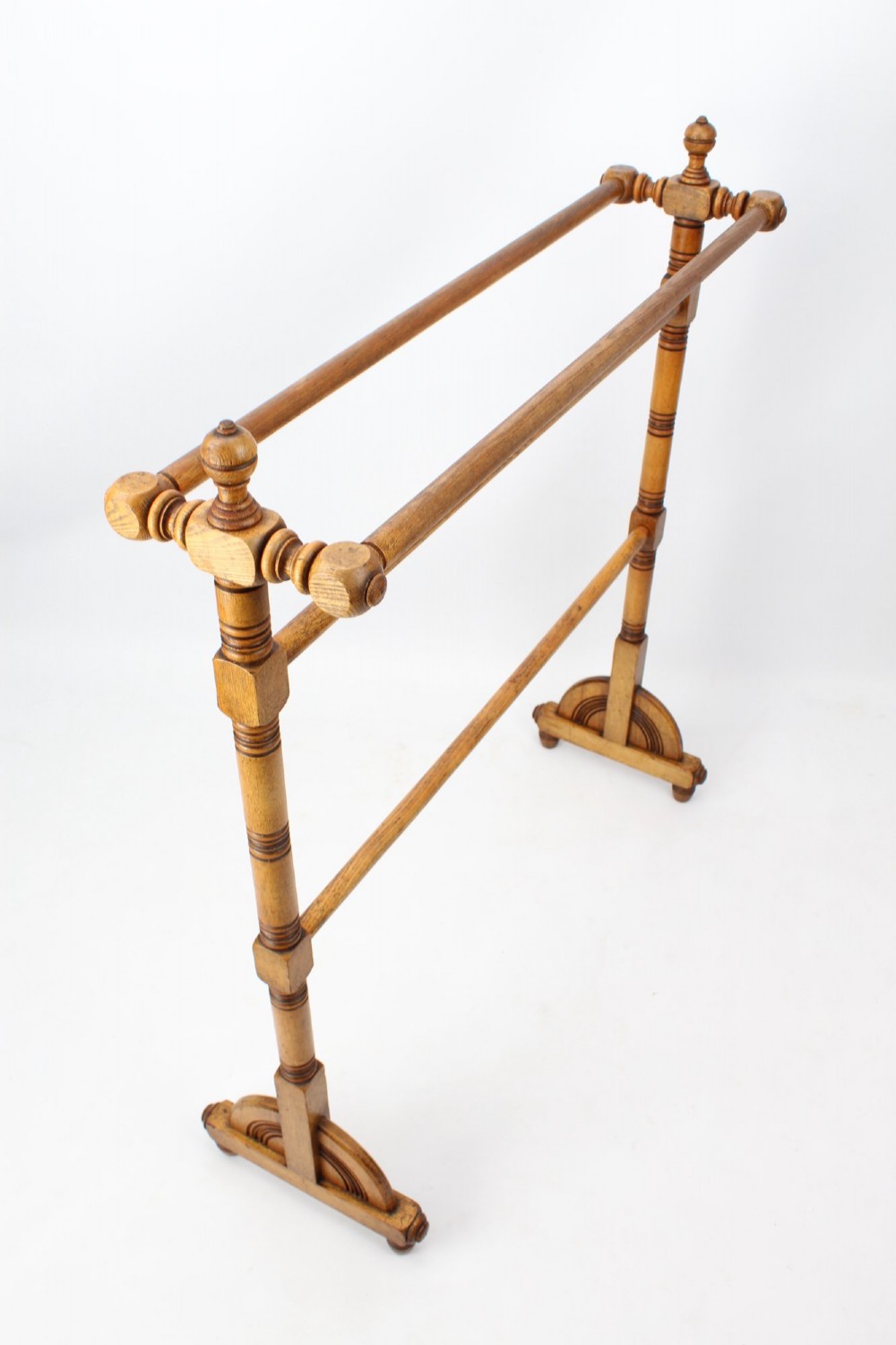 A Victorian ash freestanding towel rail featuring four horizontal bars, turned side columns with finials, and carved pedestal feet. View III