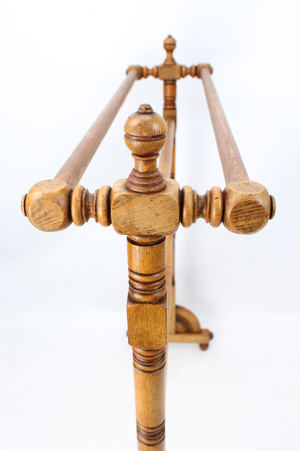 A Victorian ash freestanding towel rail featuring four horizontal bars, turned side columns with finials, and carved pedestal feet. View V