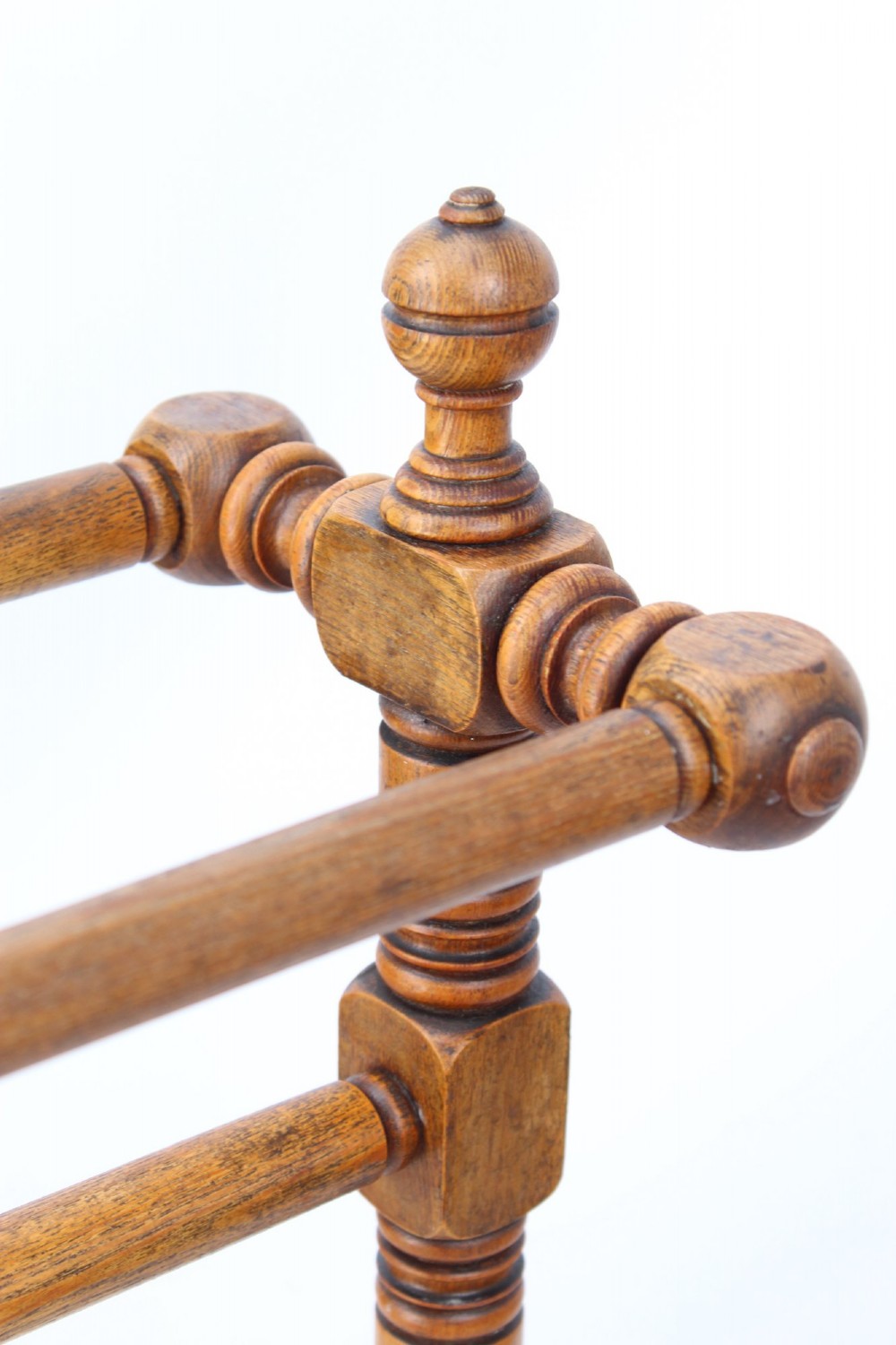 A Victorian ash freestanding towel rail featuring four horizontal bars, turned side columns with finials, and carved pedestal feet. View X