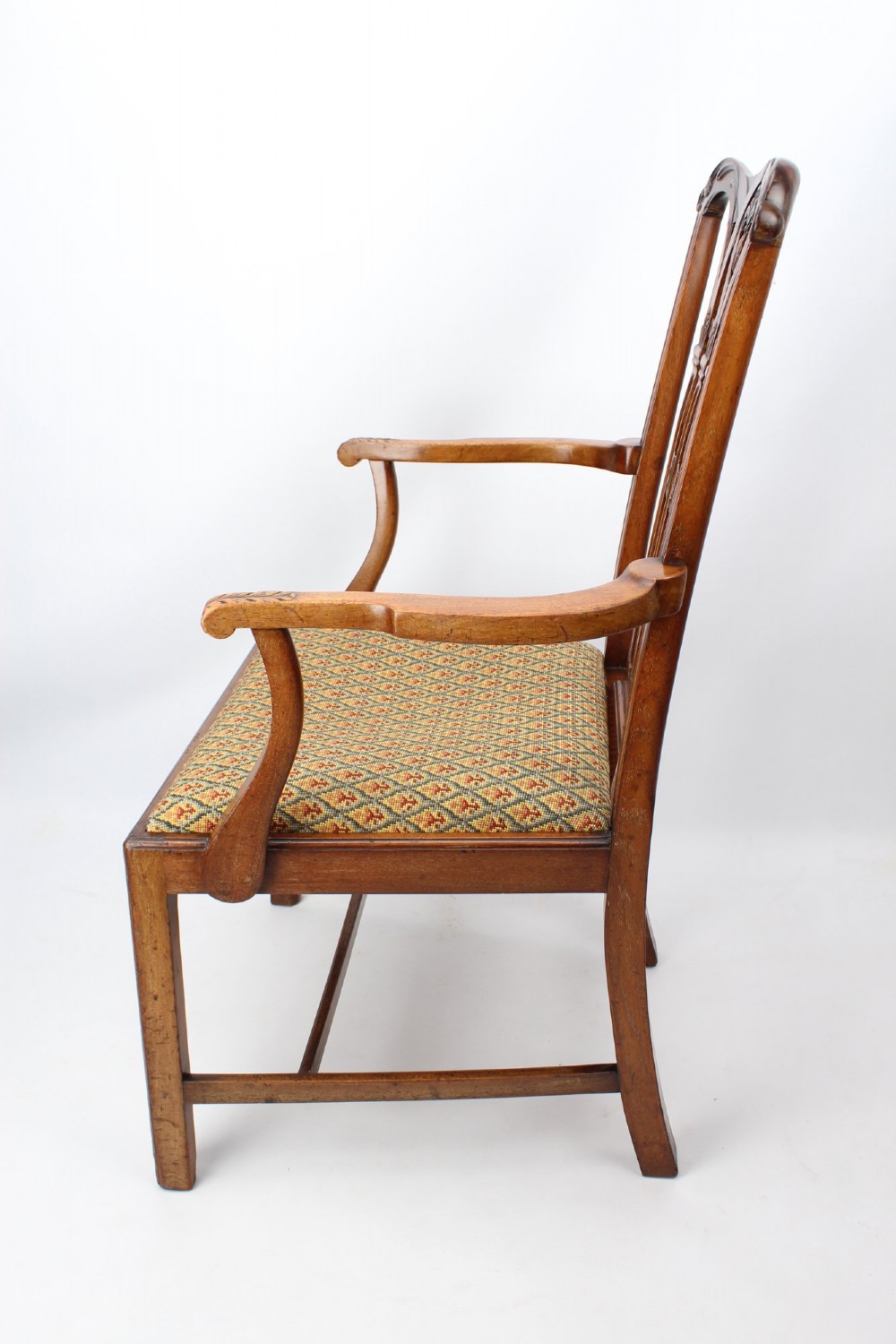 An Edwardian Chippendale style mahogany desk chair with a pierced carved back splat, curved armrests, and a patterned tapestry seat. View III