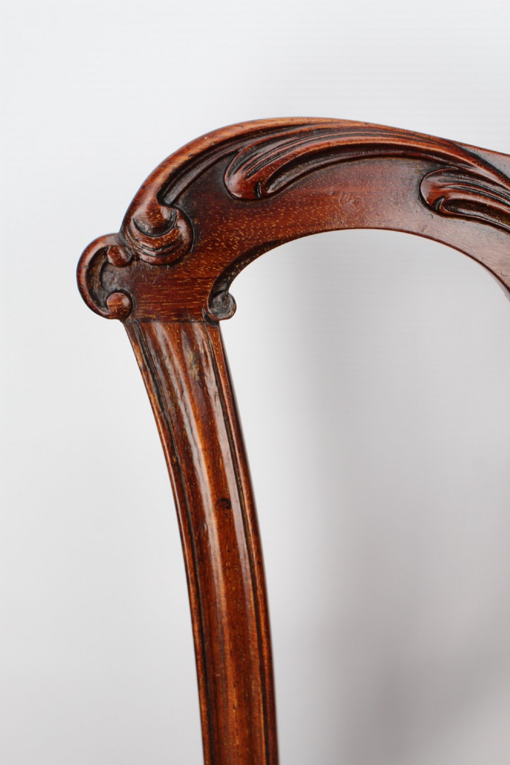 An Edwardian Chippendale style mahogany desk chair with a pierced carved back splat, curved armrests, and a patterned tapestry seat. View V