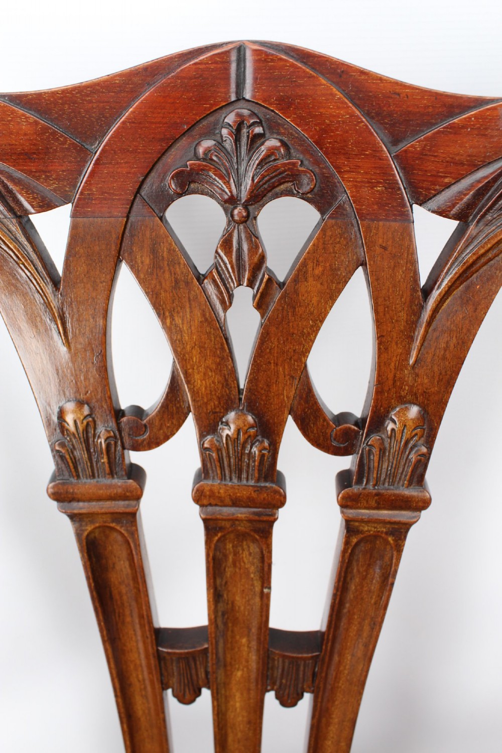An Edwardian Chippendale style mahogany desk chair with a pierced carved back splat, curved armrests, and a patterned tapestry seat. View VI
