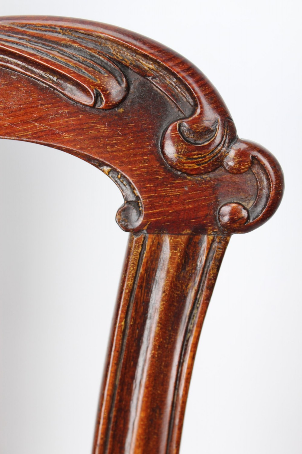 An Edwardian Chippendale style mahogany desk chair with a pierced carved back splat, curved armrests, and a patterned tapestry seat. View VII
