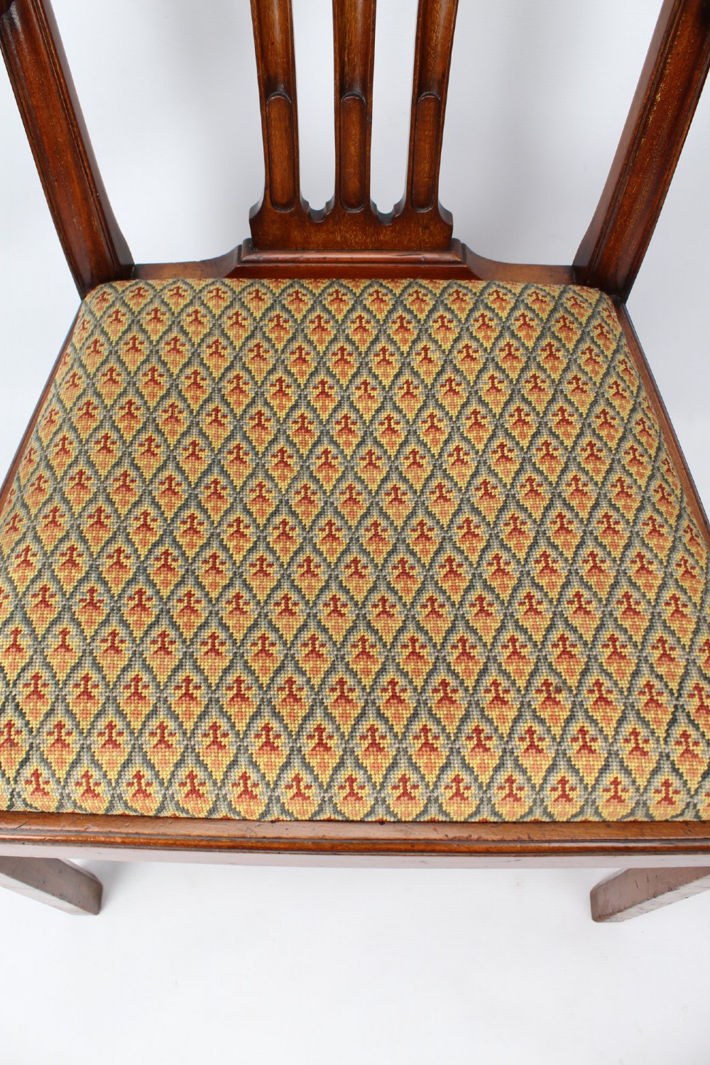 An Edwardian Chippendale style mahogany desk chair with a pierced carved back splat, curved armrests, and a patterned tapestry seat. View IX