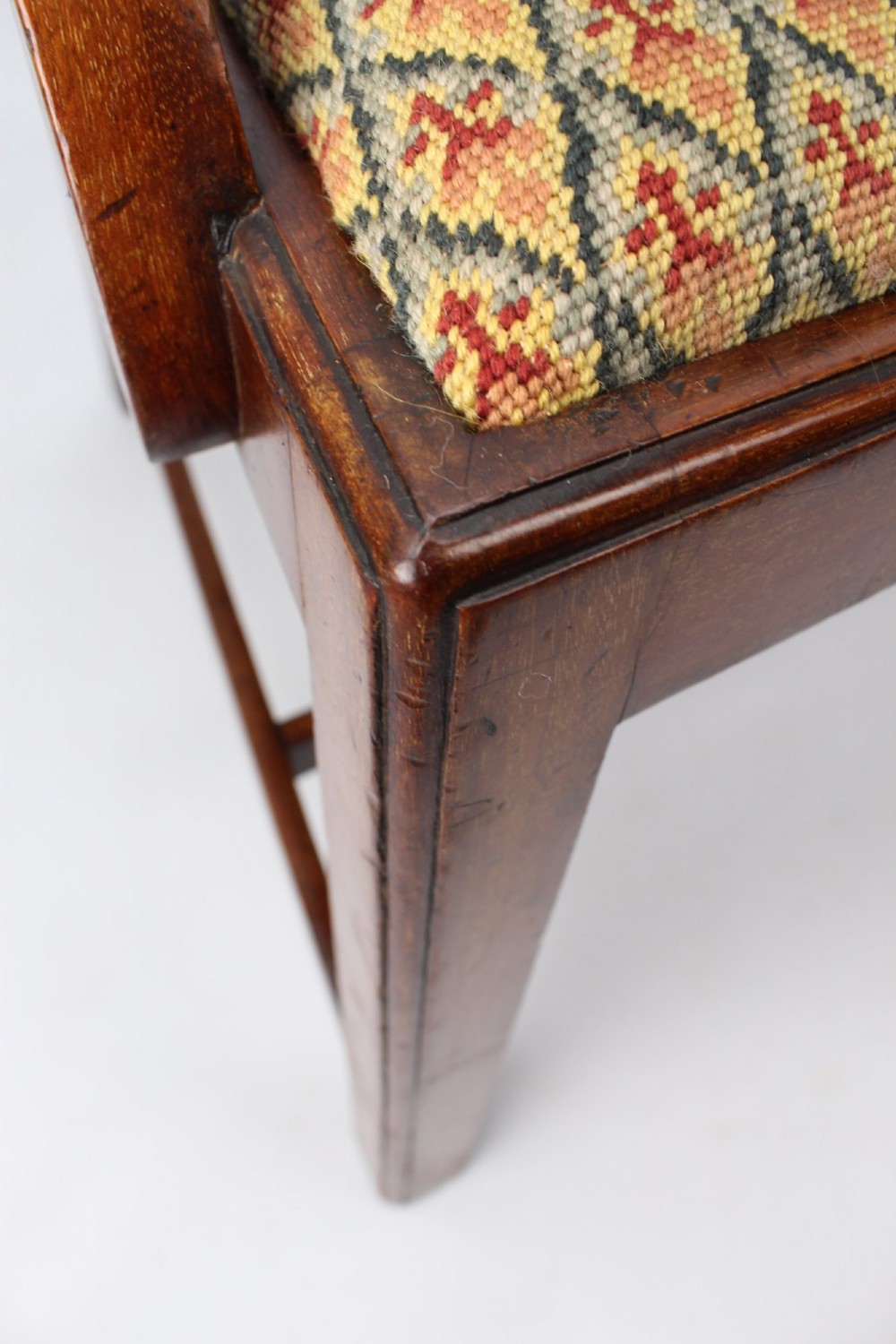 An Edwardian Chippendale style mahogany desk chair with a pierced carved back splat, curved armrests, and a patterned tapestry seat. View XI
