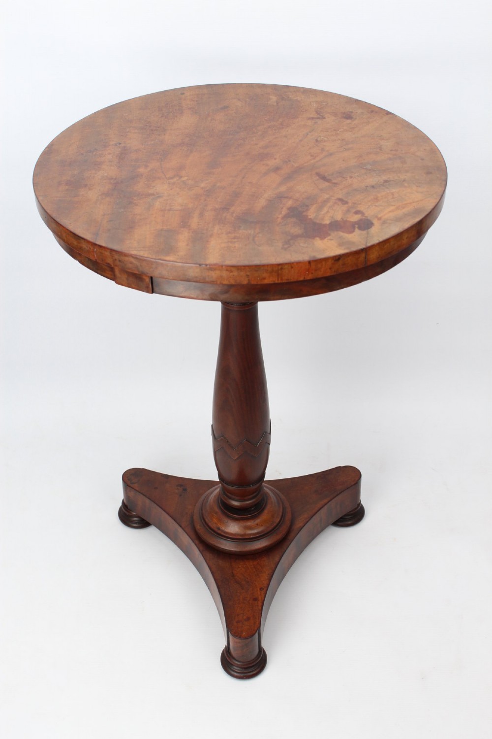 A circular mahogany wine table from the William IV period featuring a turned central column on a triform base with flattened bun feet. View III