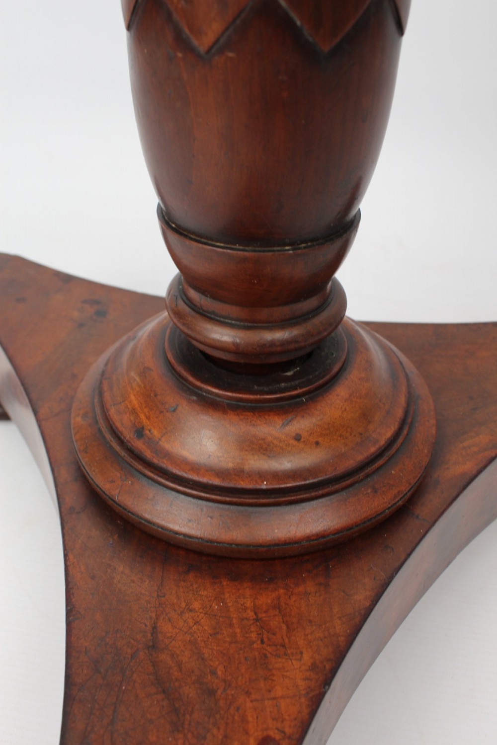 A circular mahogany wine table from the William IV period featuring a turned central column on a triform base with flattened bun feet. View VI