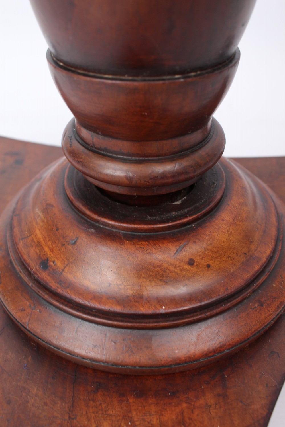 A circular mahogany wine table from the William IV period featuring a turned central column on a triform base with flattened bun feet. View VIII