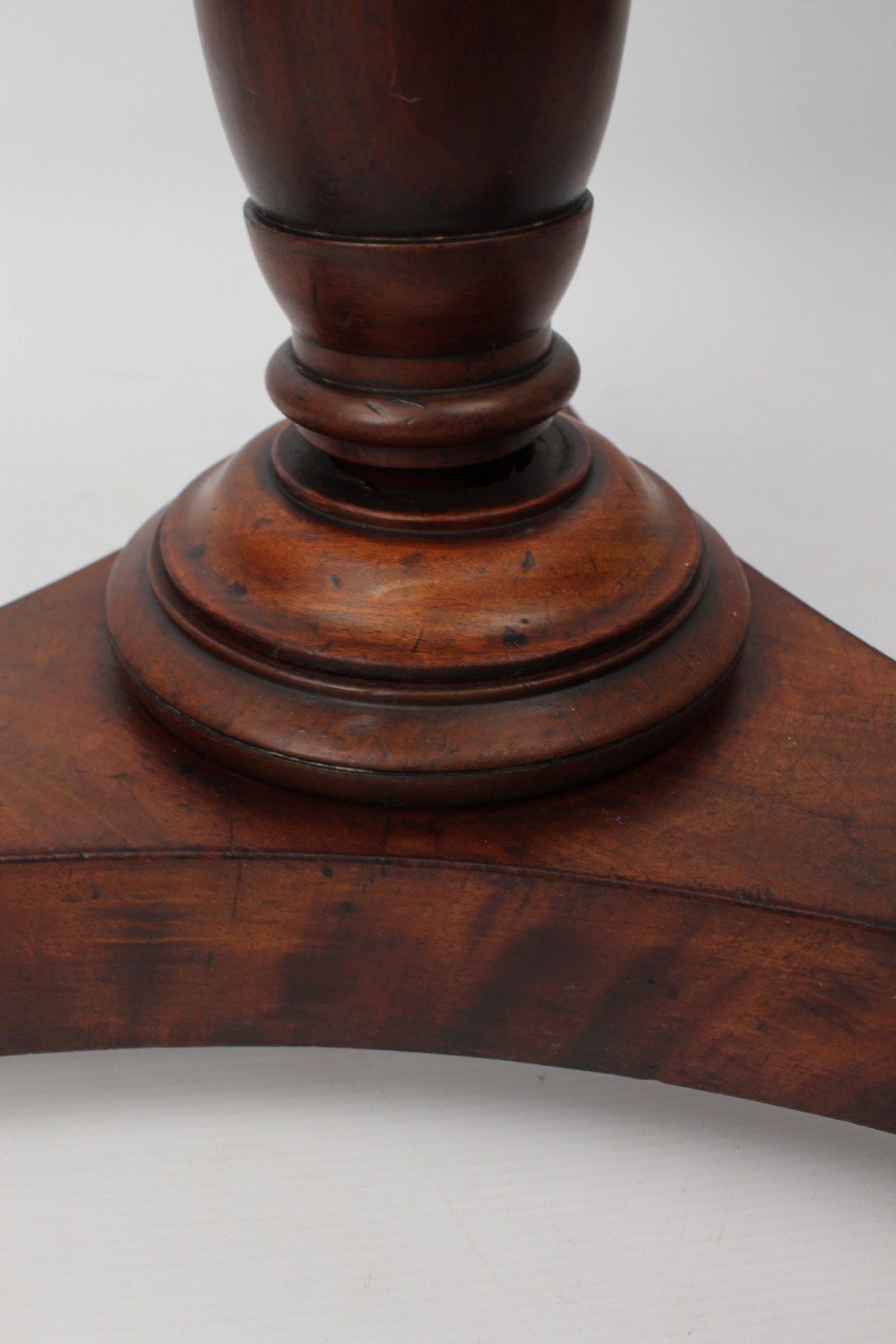 A circular mahogany wine table from the William IV period featuring a turned central column on a triform base with flattened bun feet. View IX