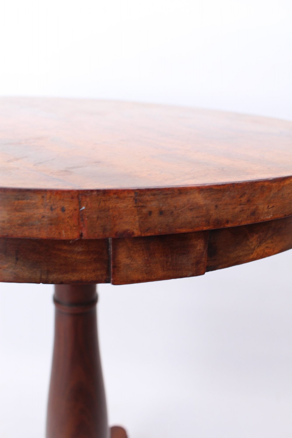 A circular mahogany wine table from the William IV period featuring a turned central column on a triform base with flattened bun feet. View XI