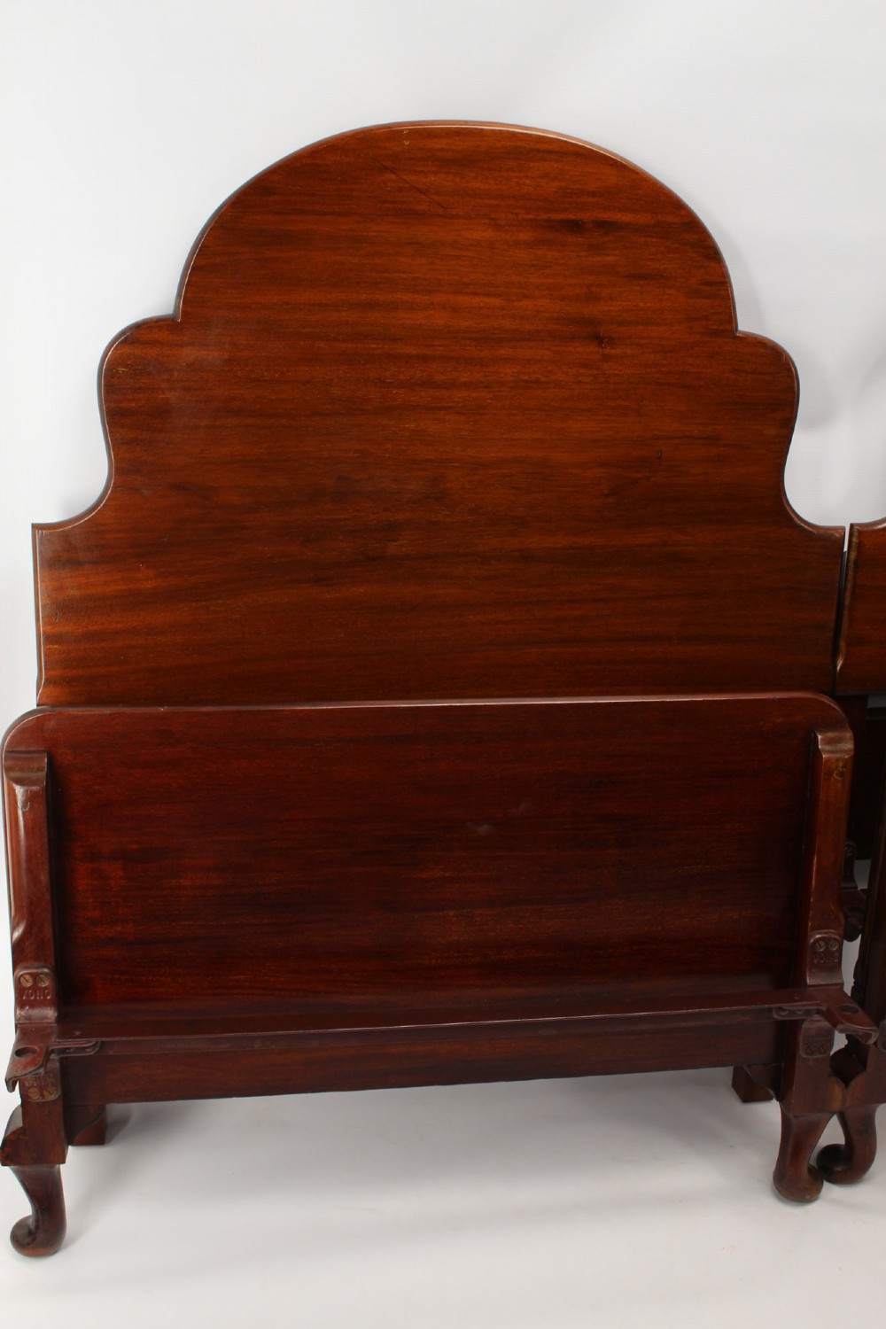 A matching pair of Art Deco mahogany single beds with stepped, arched headboards and low footboards on short cabriole feet. View III
