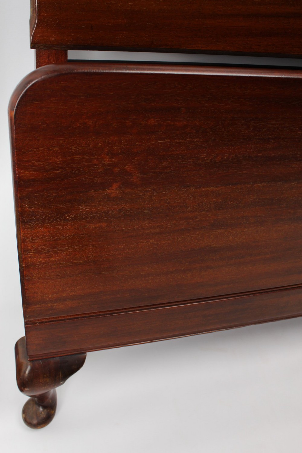 A matching pair of Art Deco mahogany single beds with stepped, arched headboards and low footboards on short cabriole feet. View IV