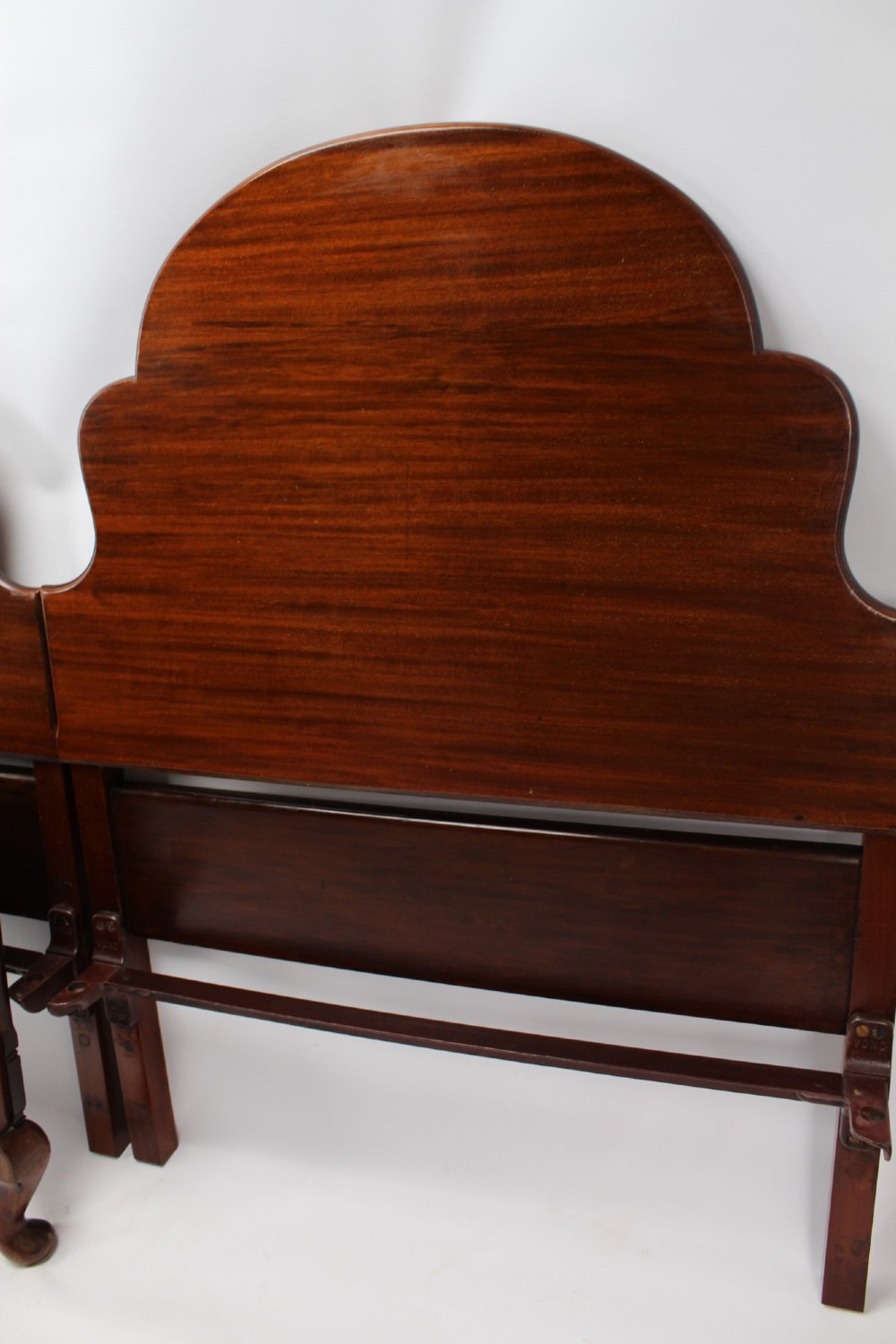 A matching pair of Art Deco mahogany single beds with stepped, arched headboards and low footboards on short cabriole feet. View VIII