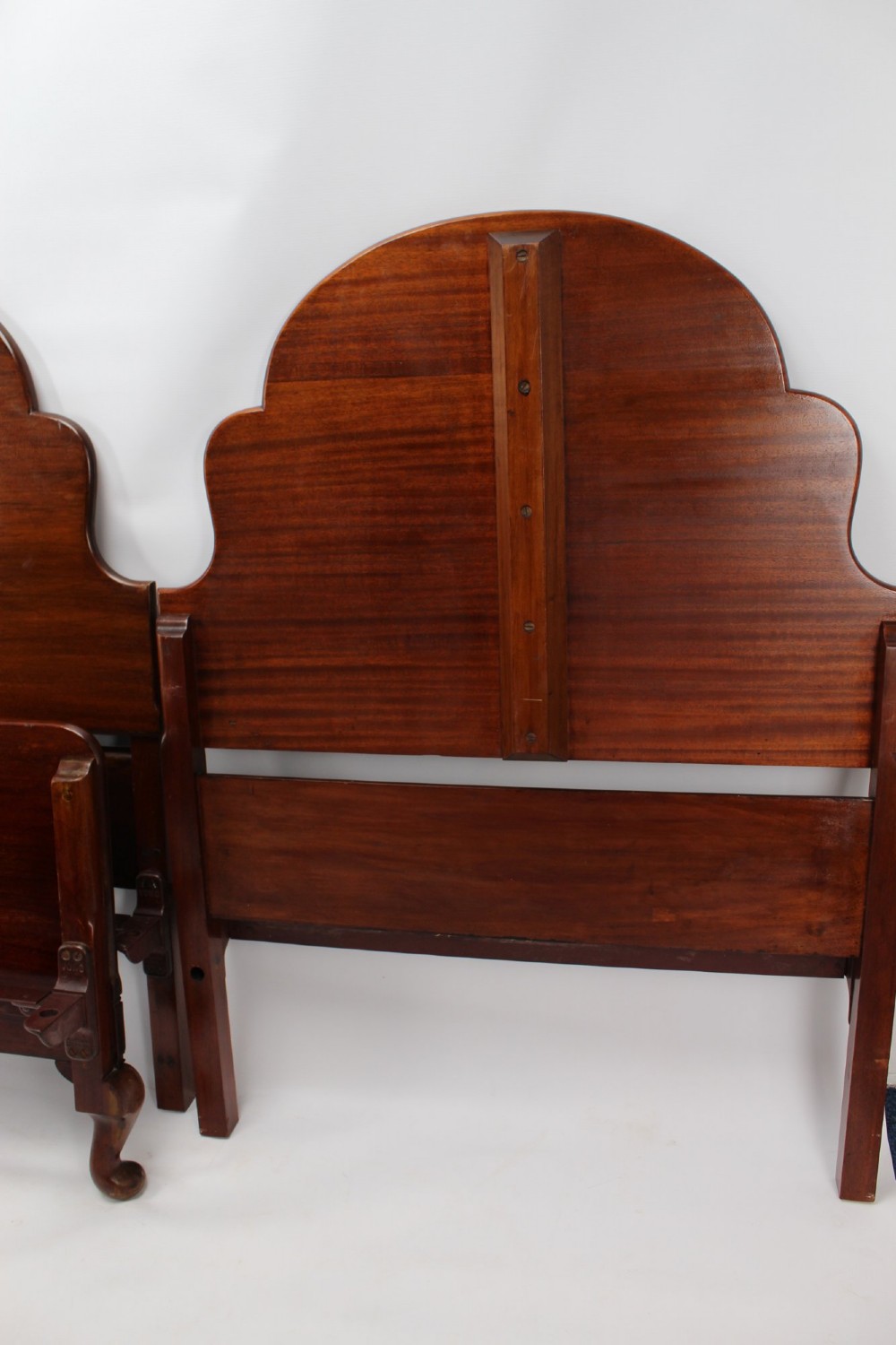 A matching pair of Art Deco mahogany single beds with stepped, arched headboards and low footboards on short cabriole feet. View XII