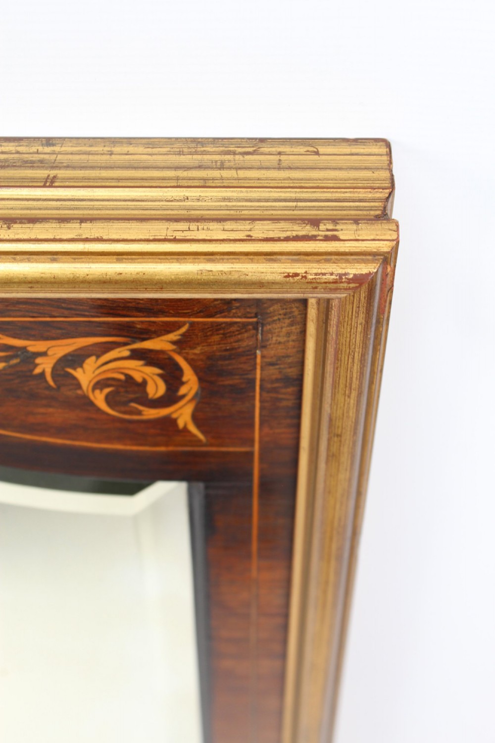 A rectangular rosewood wall mirror featuring gilt outer moulding, floral corner marquetry inlays, and an arched bevelled glass plate. View V