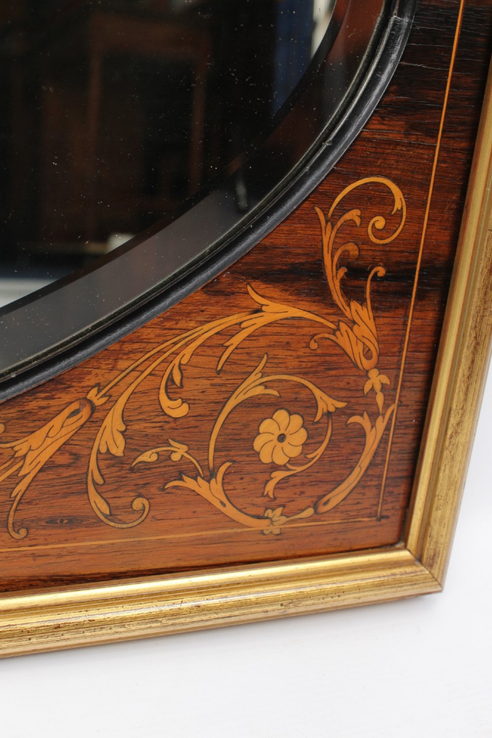 A rectangular rosewood wall mirror featuring gilt outer moulding, floral corner marquetry inlays, and an arched bevelled glass plate. View IX