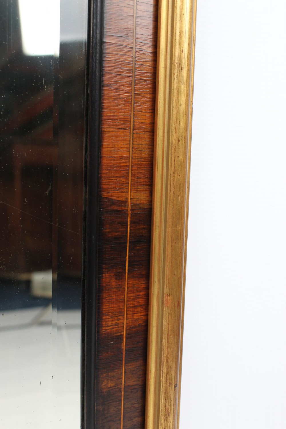 A rectangular rosewood wall mirror featuring gilt outer moulding, floral corner marquetry inlays, and an arched bevelled glass plate. View X