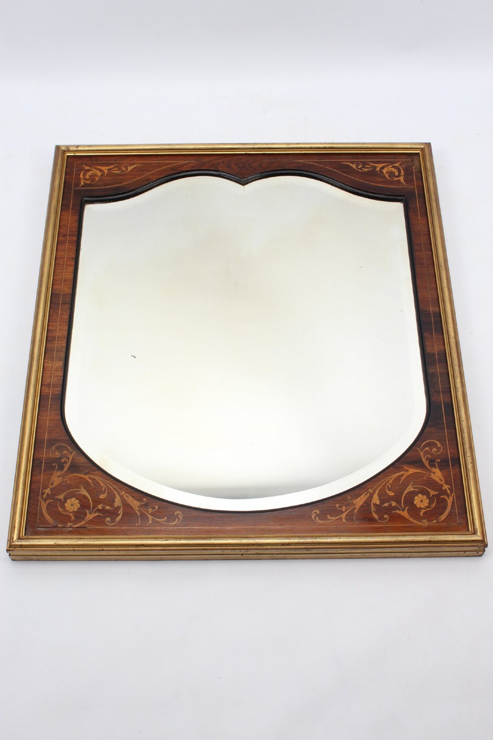 A rectangular rosewood wall mirror featuring gilt outer moulding, floral corner marquetry inlays, and an arched bevelled glass plate. View XII