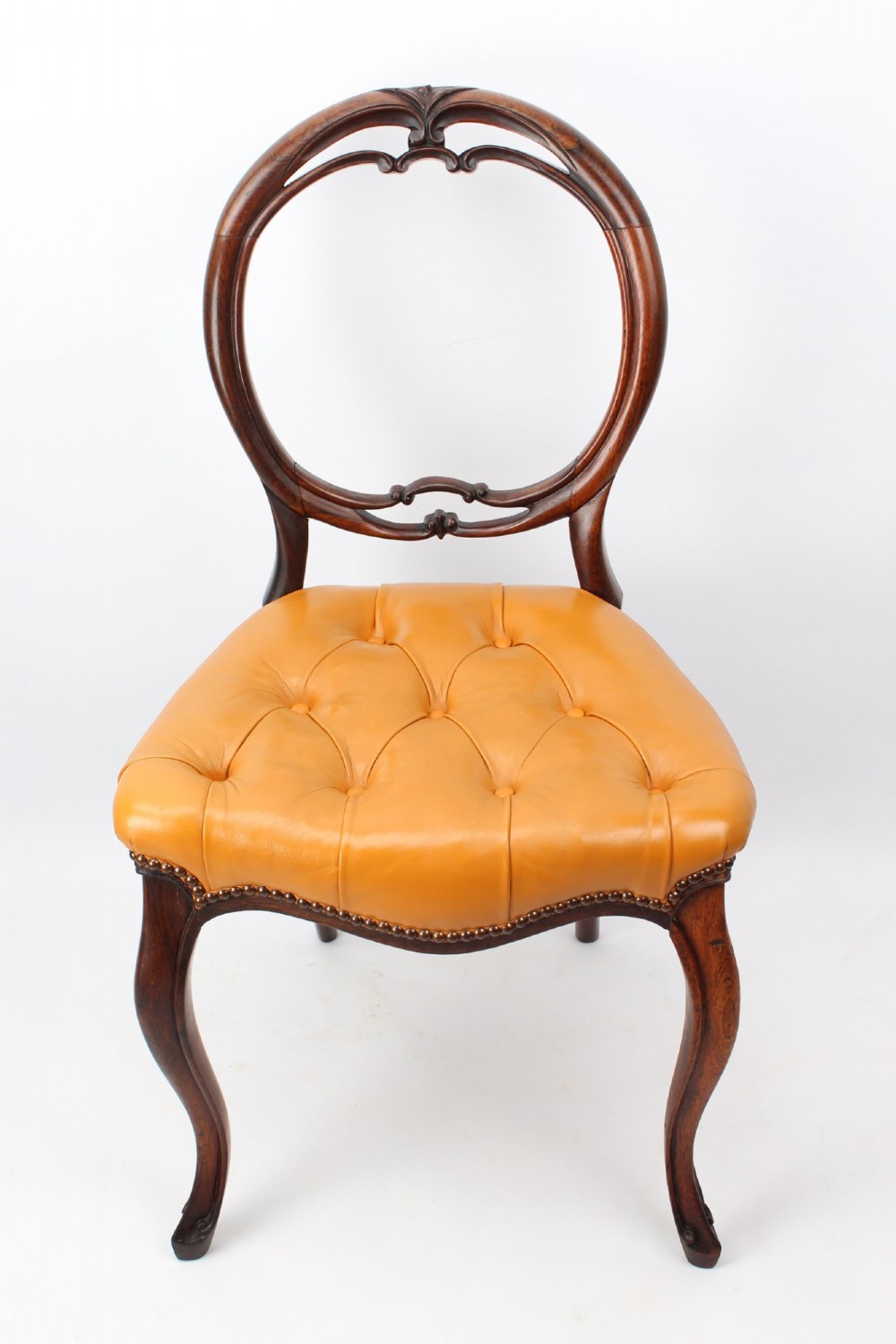 A pair of Victorian rosewood balloon back side chairs featuring button-tufted tan leather upholstery and cabriole front legs. View II