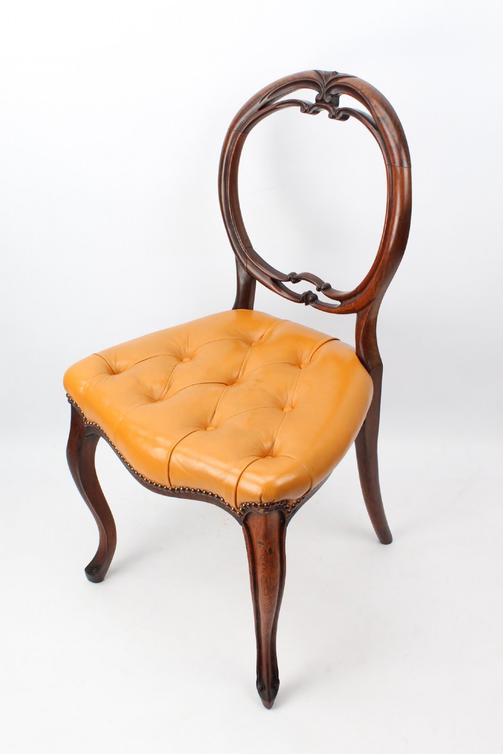 A pair of Victorian rosewood balloon back side chairs featuring button-tufted tan leather upholstery and cabriole front legs. View III