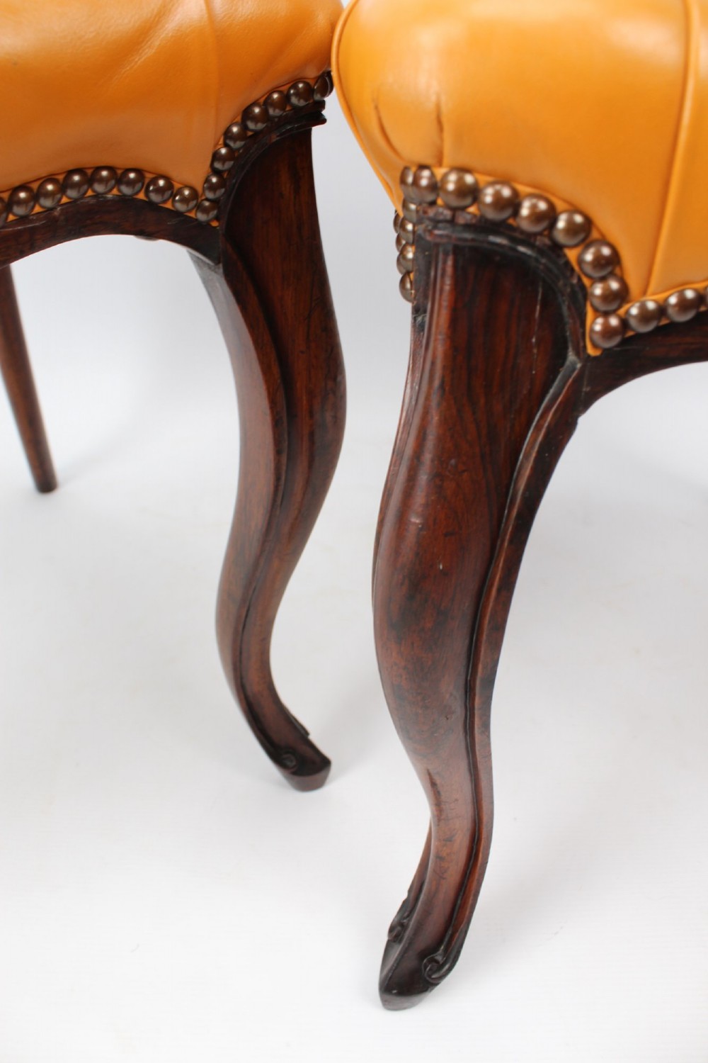 A pair of Victorian rosewood balloon back side chairs featuring button-tufted tan leather upholstery and cabriole front legs. View XI