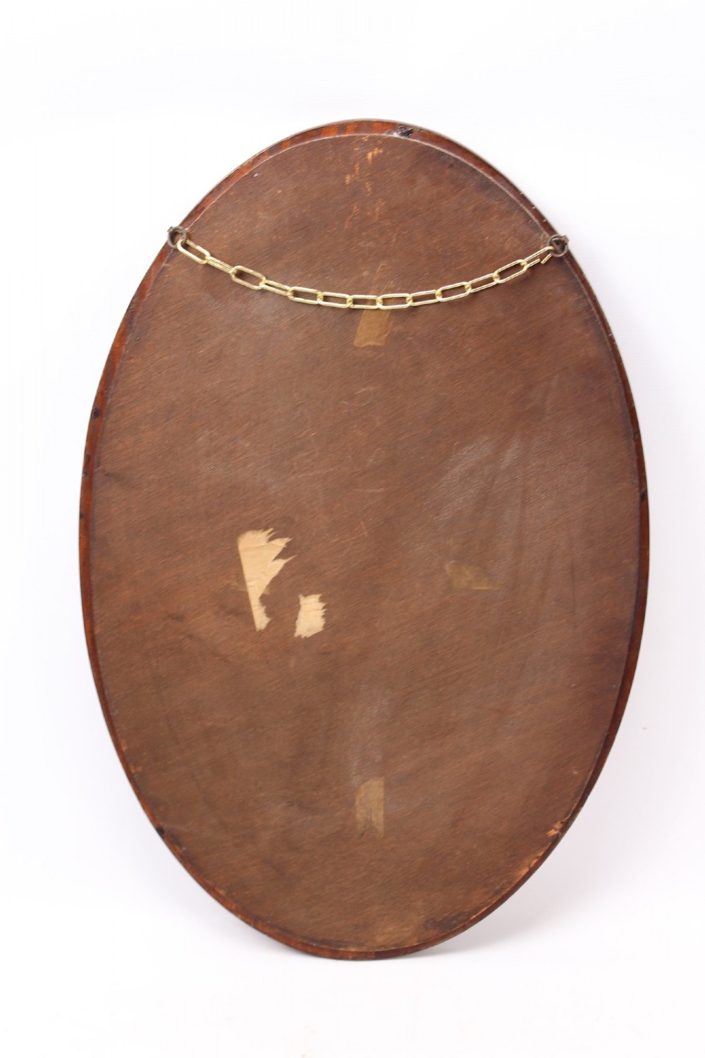 An oval wall mirror framed in warm mahogany timber with geometric chequered inlay along the outer border. View XII