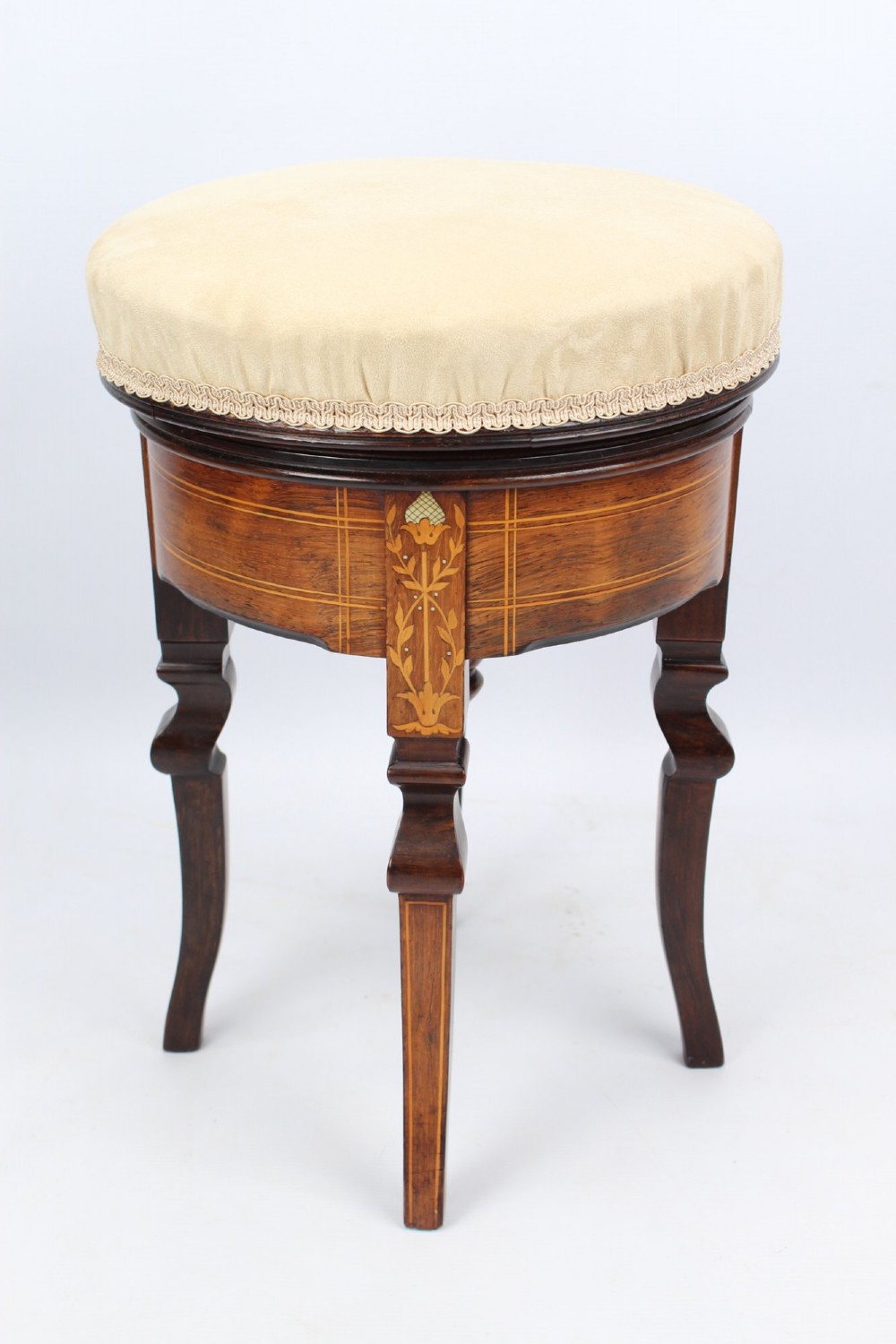 A circular padded beige stool on a dark rosewood base featuring floral marquetry and curved legs.