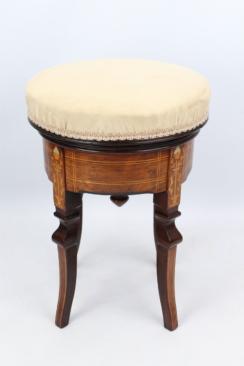 A circular padded beige stool on a dark rosewood base featuring floral marquetry and curved legs. View II
