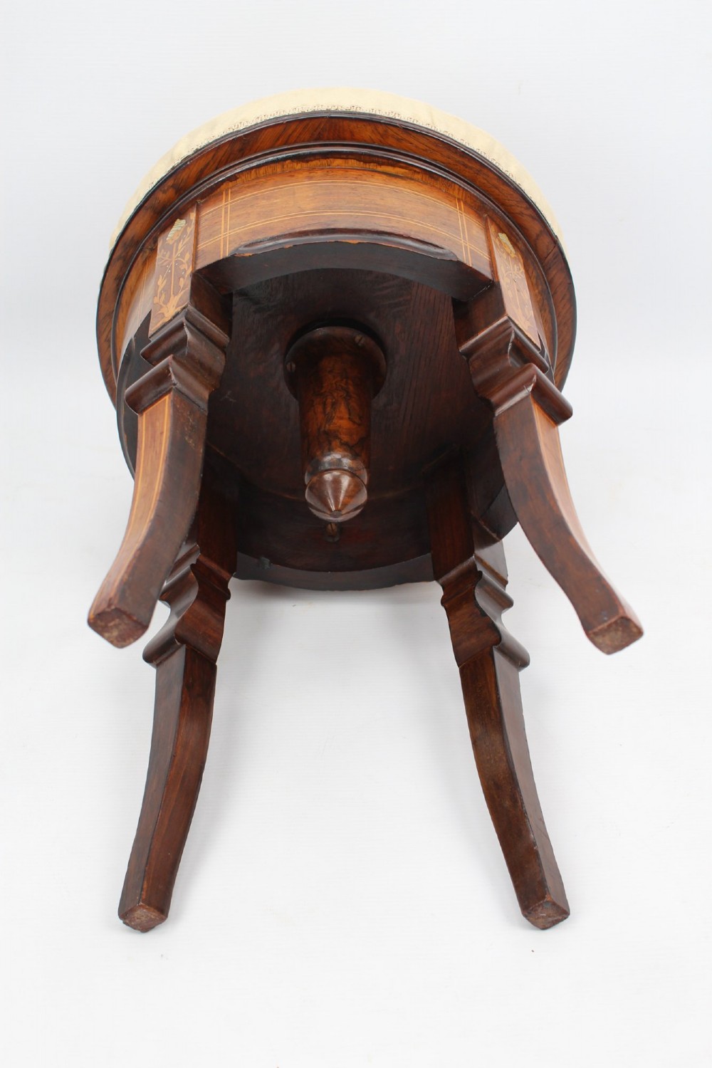A circular padded beige stool on a dark rosewood base featuring floral marquetry and curved legs. View VIII