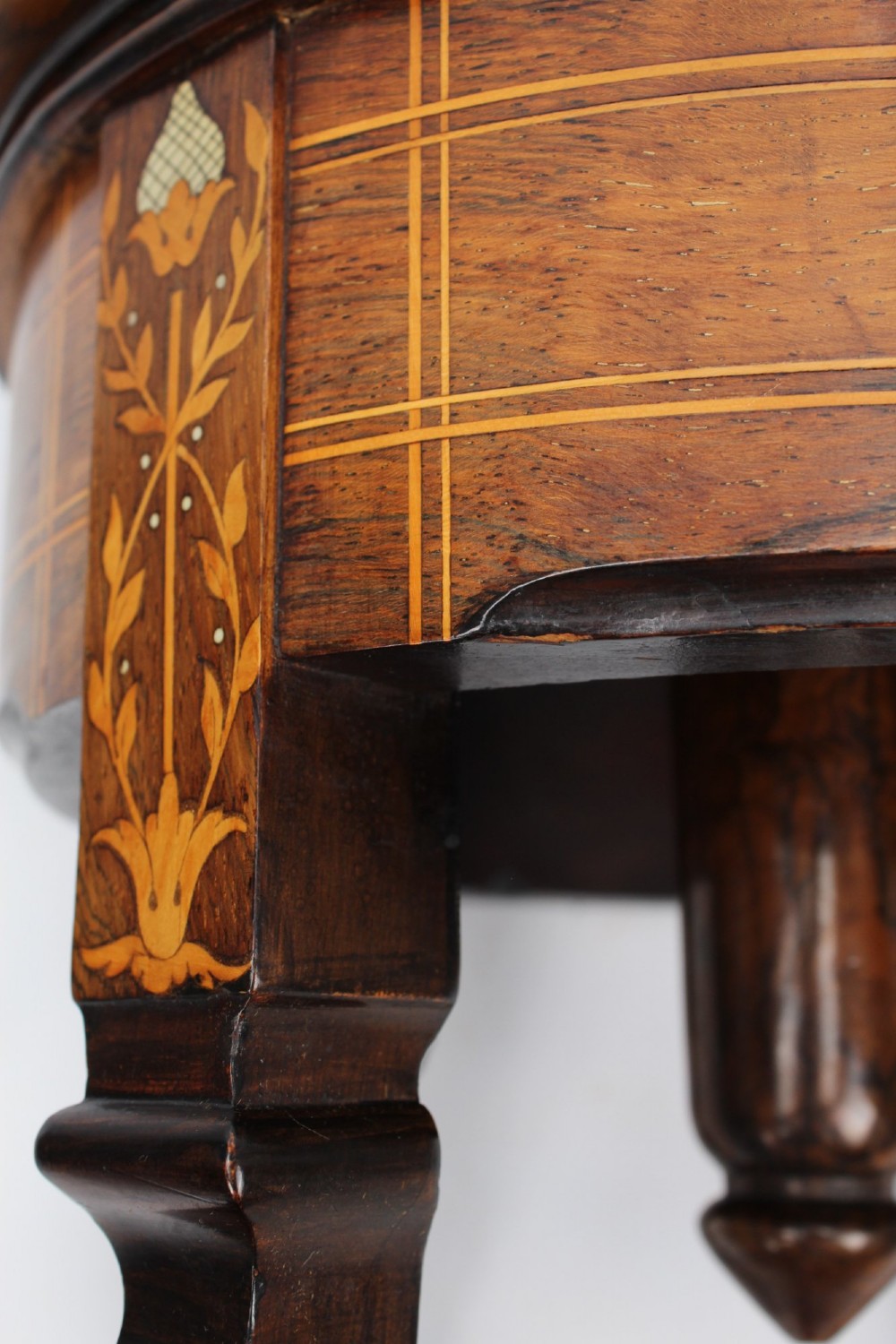 A circular padded beige stool on a dark rosewood base featuring floral marquetry and curved legs. View X