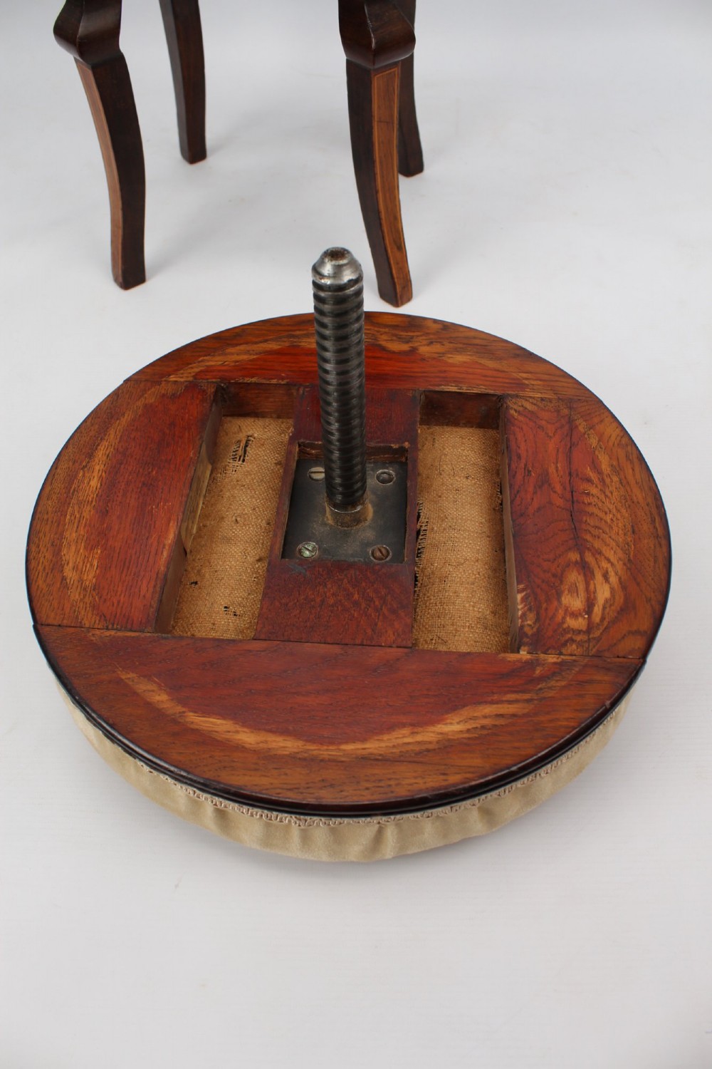 A circular padded beige stool on a dark rosewood base featuring floral marquetry and curved legs. View XII