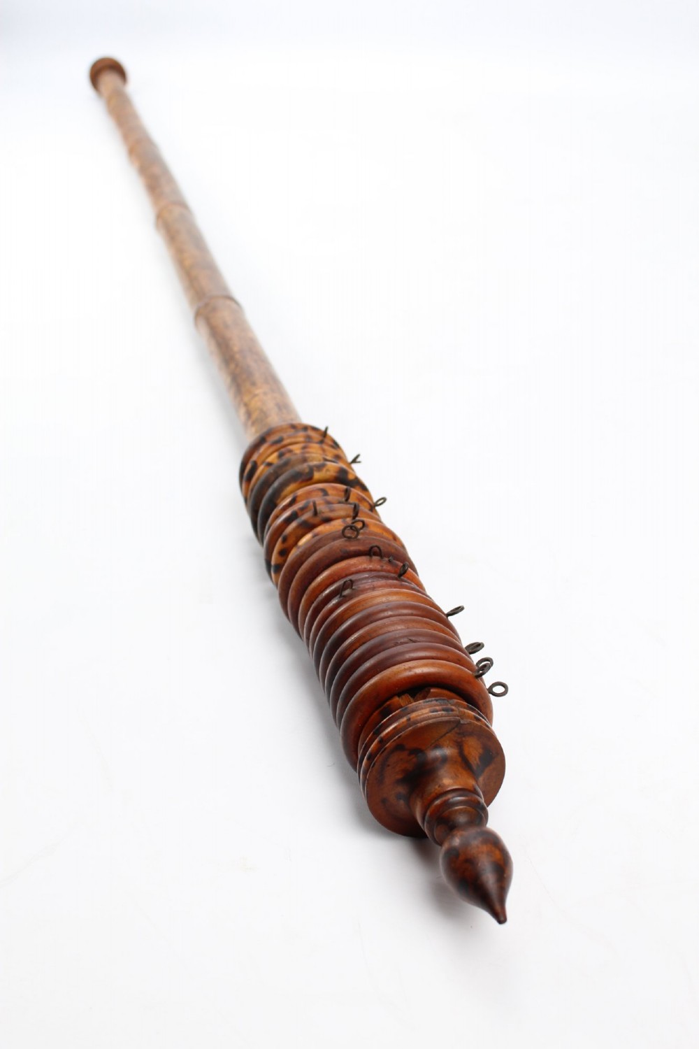 A long natural bamboo curtain pole featuring turned wooden finials at both ends and a set of matching wooden curtain rings stacked near one end. View III