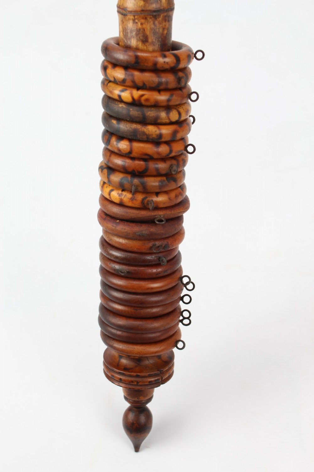 A long natural bamboo curtain pole featuring turned wooden finials at both ends and a set of matching wooden curtain rings stacked near one end. View V