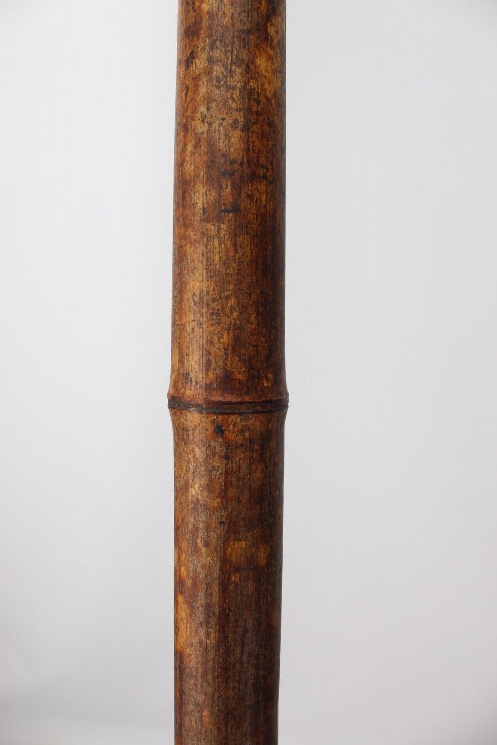 A long natural bamboo curtain pole featuring turned wooden finials at both ends and a set of matching wooden curtain rings stacked near one end. View X