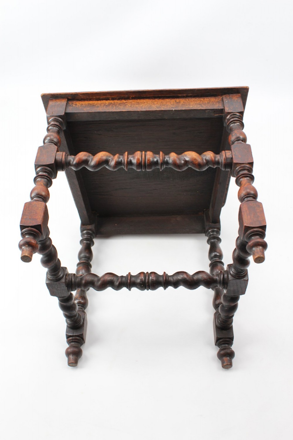 A set of four Victorian Gothic Revival dark oak chairs featuring carved floral crestings, barley twist supports, and carved geometric patterned wooden seats. View VII
