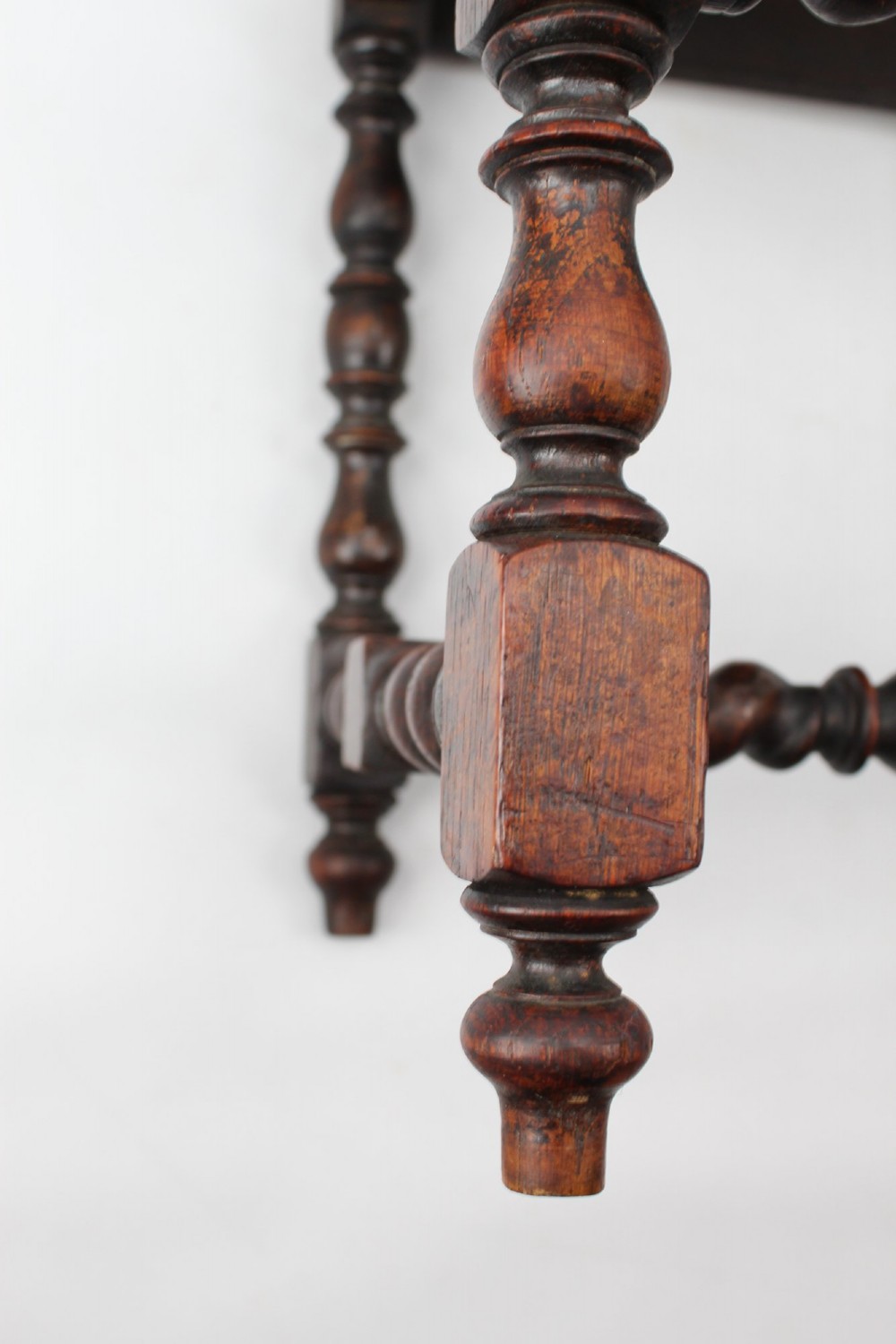 A set of four Victorian Gothic Revival dark oak chairs featuring carved floral crestings, barley twist supports, and carved geometric patterned wooden seats. View VIII