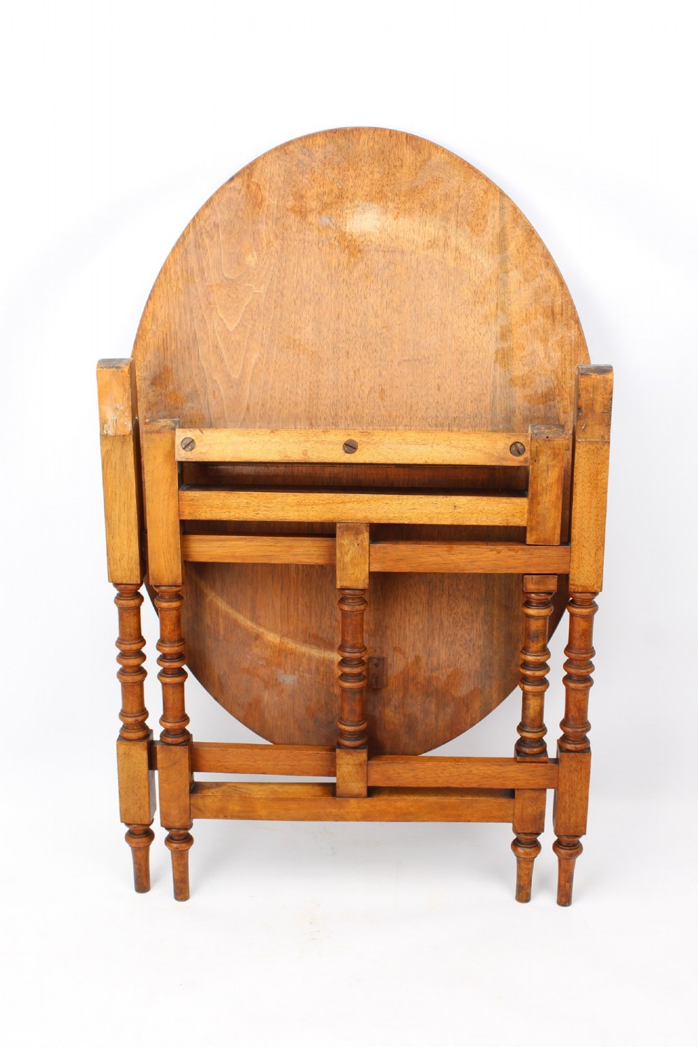 A Victorian burr walnut oval table shown with its top tilted vertically on a wooden frame with turned legs. View II