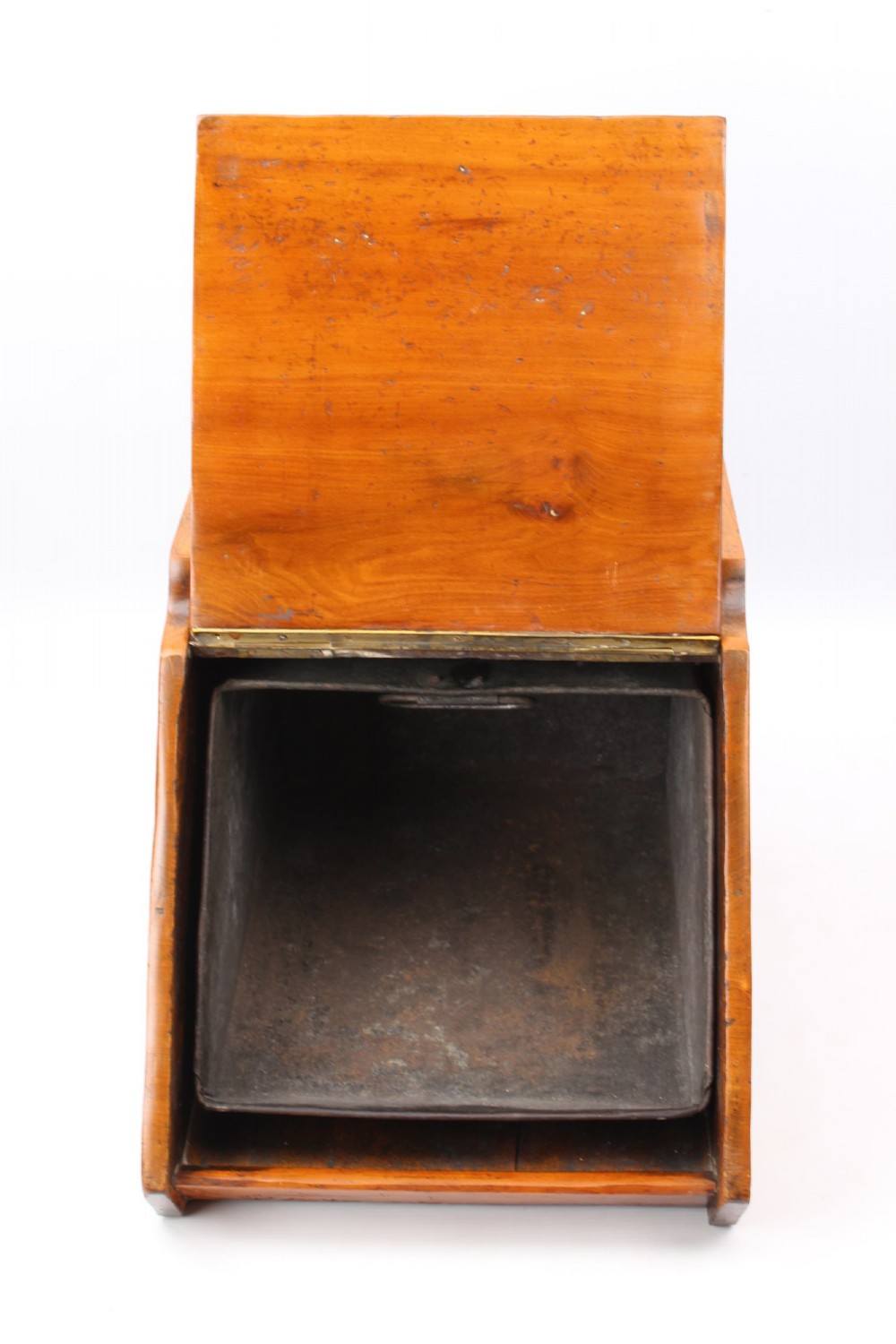 A slant-front Victorian wooden coal scuttle featuring carved floral motifs, a brass top handle, and a metal shovel stowed at the back. View III