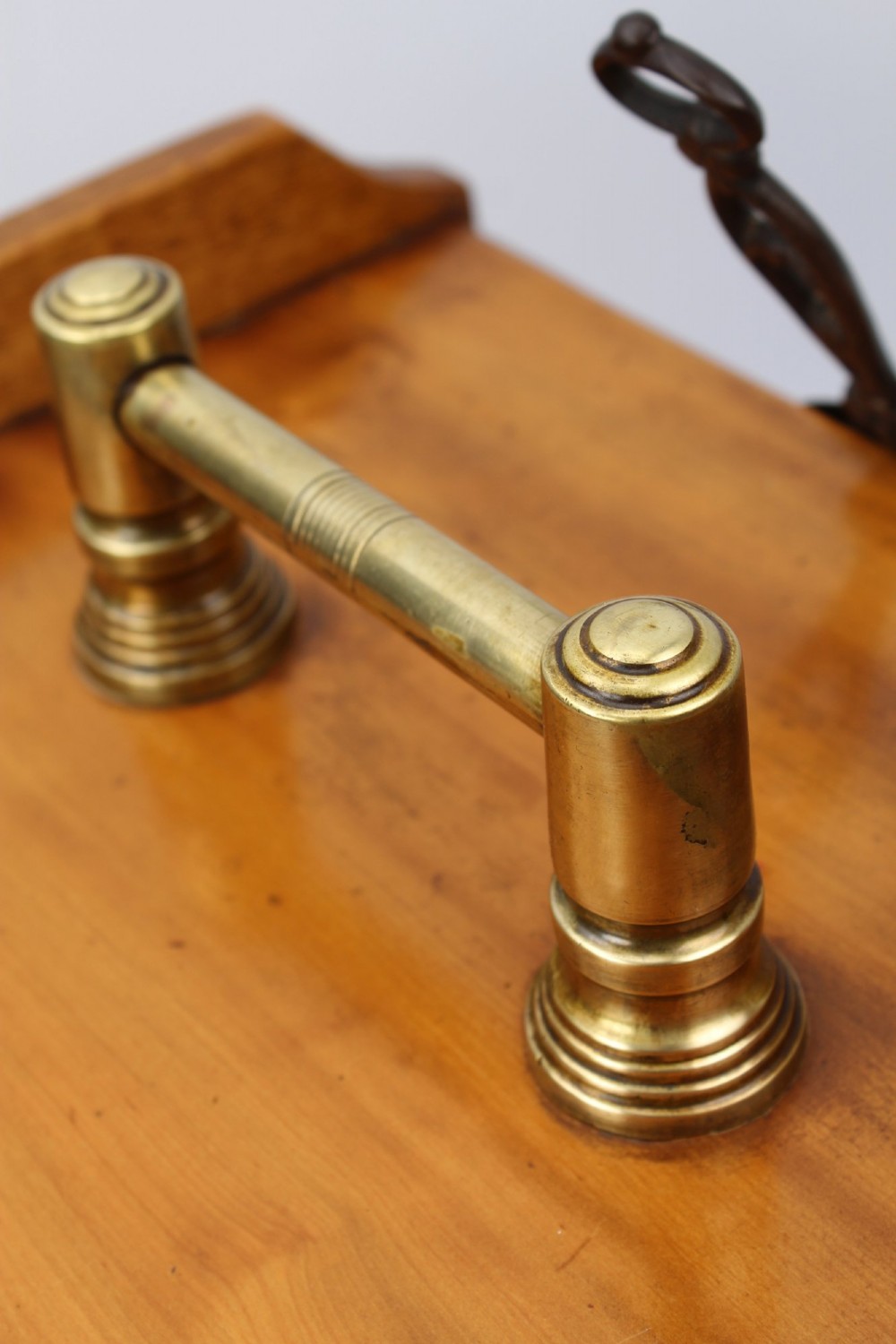 A slant-front Victorian wooden coal scuttle featuring carved floral motifs, a brass top handle, and a metal shovel stowed at the back. View VII
