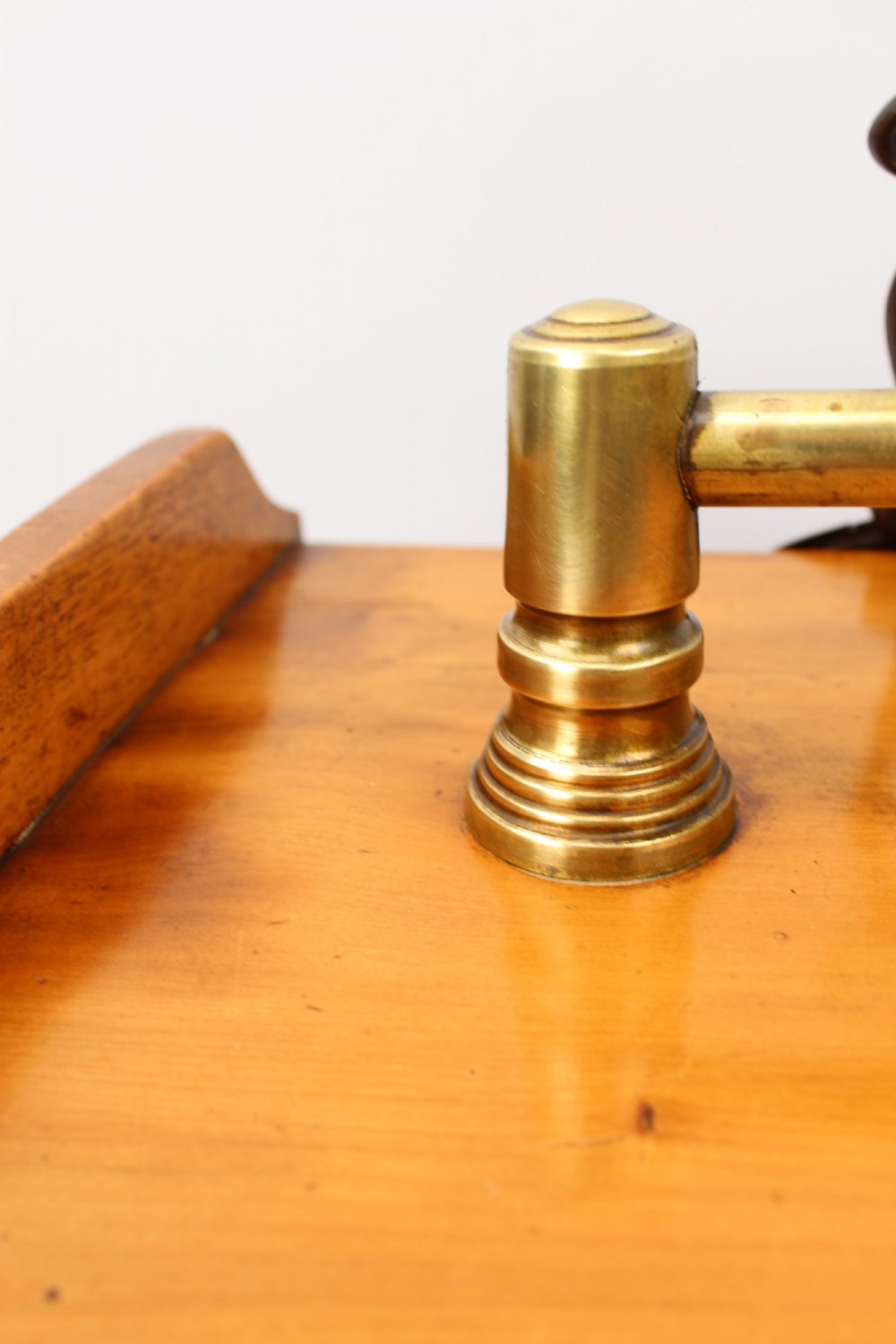 A slant-front Victorian wooden coal scuttle featuring carved floral motifs, a brass top handle, and a metal shovel stowed at the back. View XI