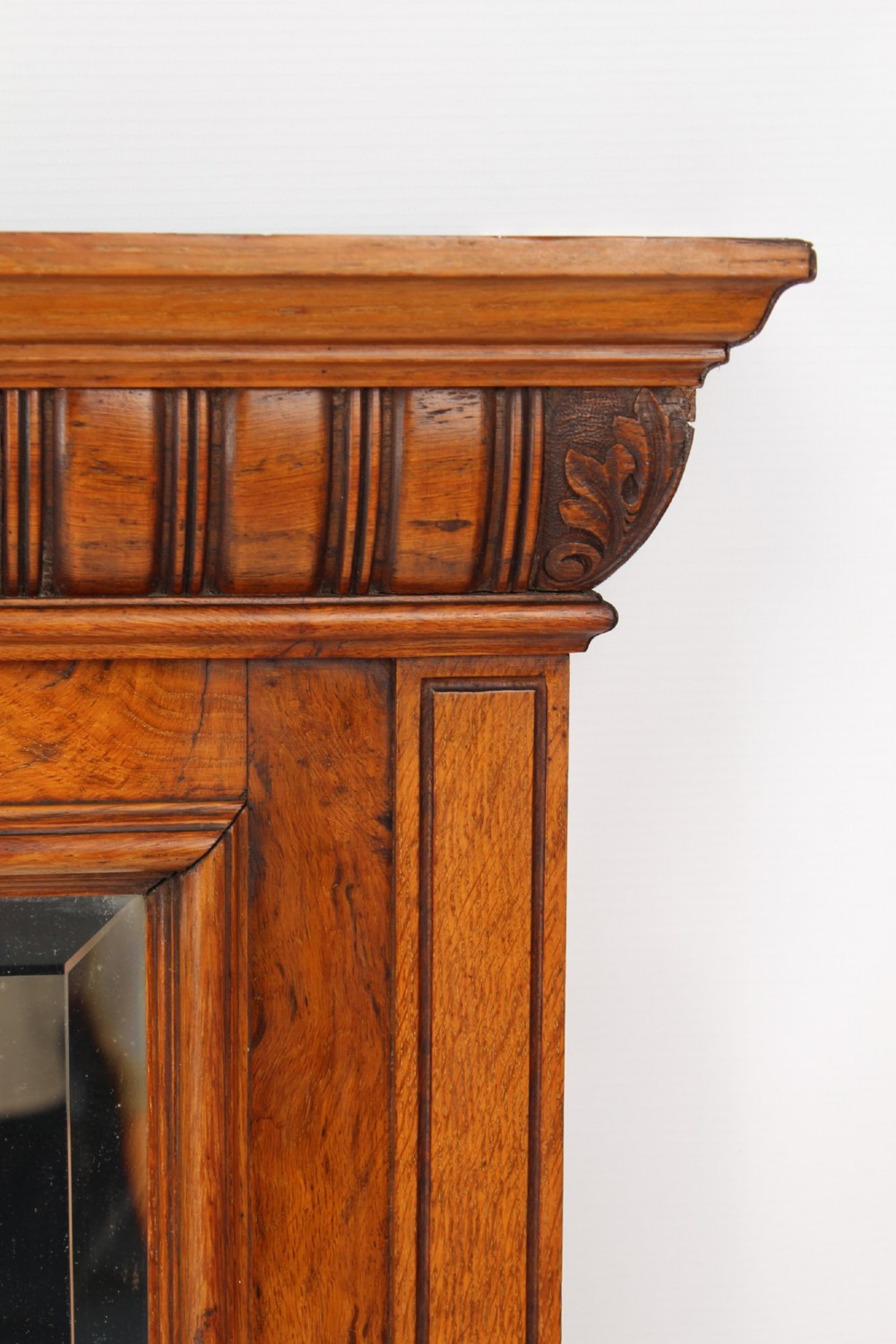 A large rectangular Victorian oak overmantel mirror featuring a moulded frame with a fluted frieze top cornice and carved side rosettes. View IV