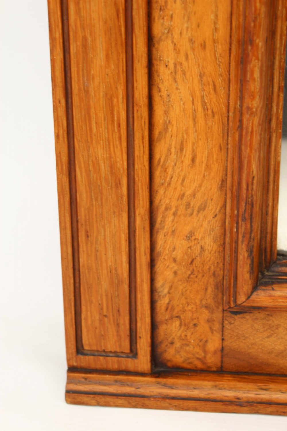 A large rectangular Victorian oak overmantel mirror featuring a moulded frame with a fluted frieze top cornice and carved side rosettes. View VII