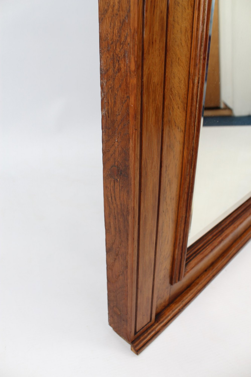 A large rectangular Victorian oak overmantel mirror featuring a moulded frame with a fluted frieze top cornice and carved side rosettes. View VIII