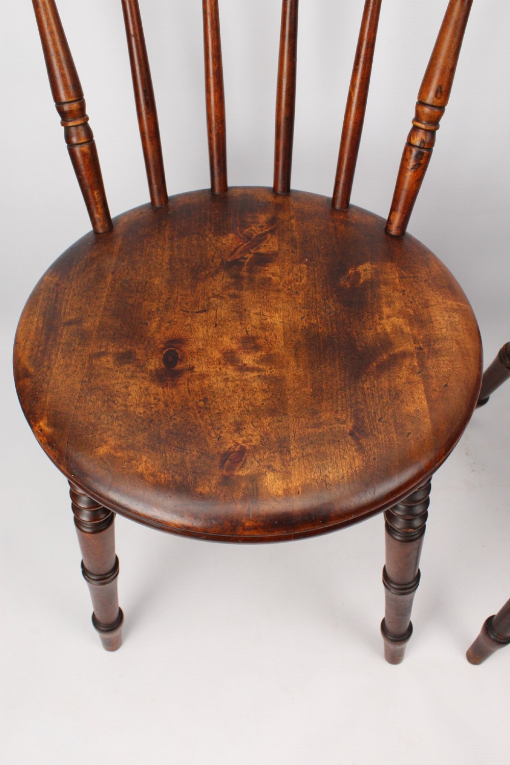 A pair of warm brown wooden kitchen chairs featuring spindle backs, turned legs, and solid timber seats. View VIII
